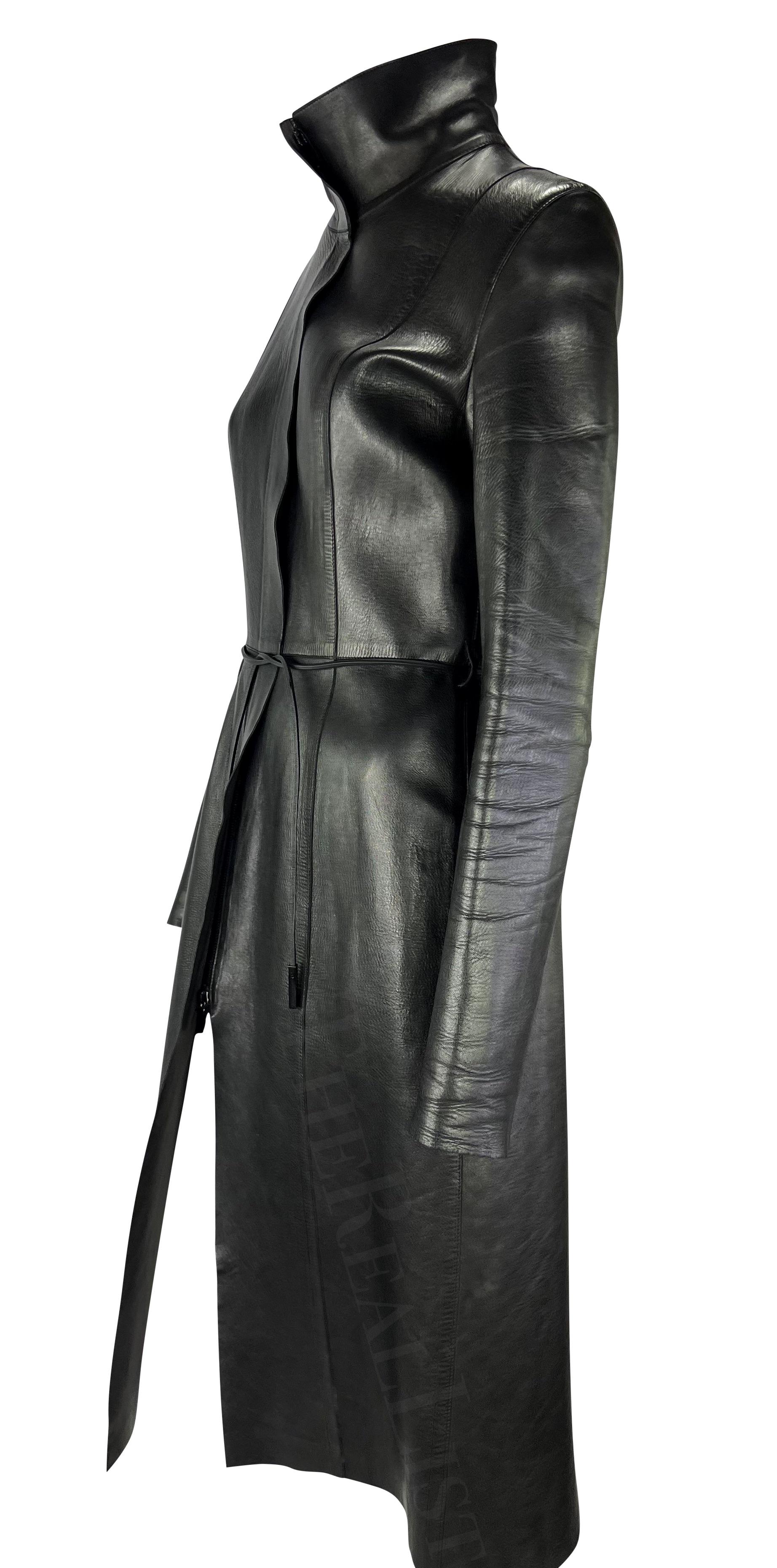 Presenting a fabulous black leather Gucci trench coat, designed by Tom Ford. From the Fall/Winter 1999 collection, this coat is constructed entirely of leather and features a stand-up collar, hidden zipper closure, and matching leather belt.
