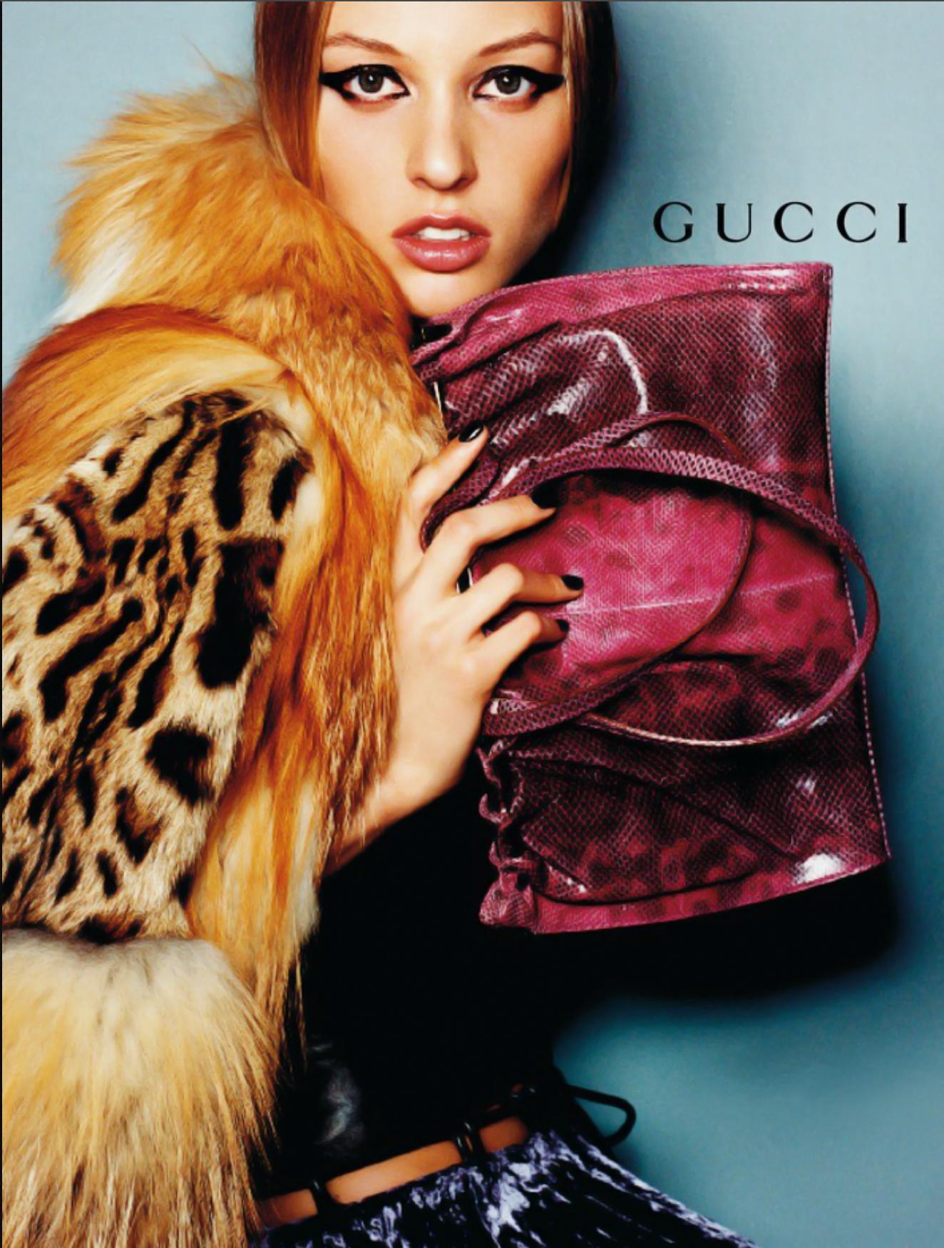 The Fall/Winter 1999 Gucci shoulder bag, designed by Tom Ford, is crafted from green karung snakeskin with a natural ombré effect in earthy tones. It features a structured silver-tone bar closure at the top, creating a gathered silhouette. Long,