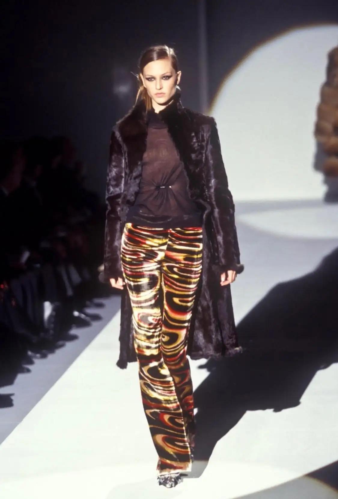 This exquisite bucket bag from Gucci's Fall/Winter 1999 collection, designed by Tom Ford, showcases his iconic psychedelic silk velvet pattern. The bag features a sleek lucite hoop handle, attached by silver metal rings that harmonize beautifully