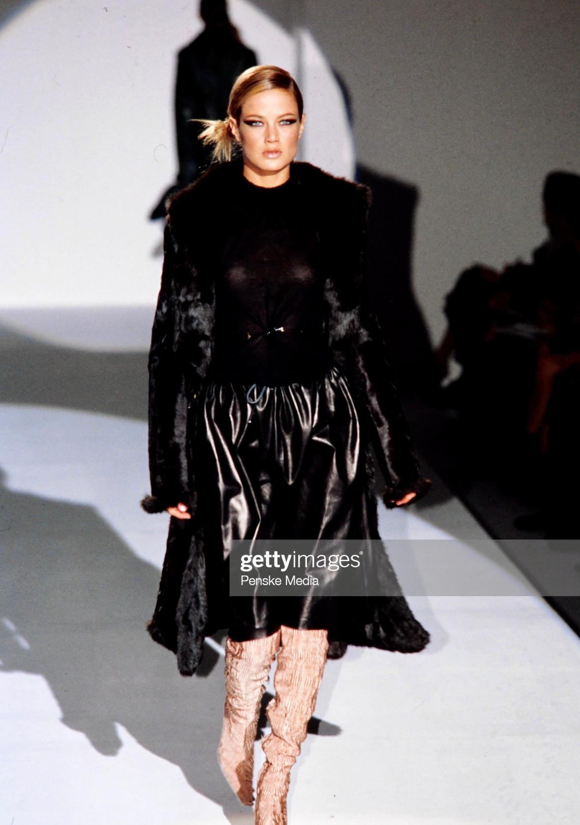 Présentation d'une incroyable jupe Gucci en cuir noir, dessinée par Tom Ford. Issue de la collection automne-hiver 1999, cette jupe a fait ses débuts sur les podiums de la saison. Entièrement en cuir, cette jupe présente de légers plis à la taille,