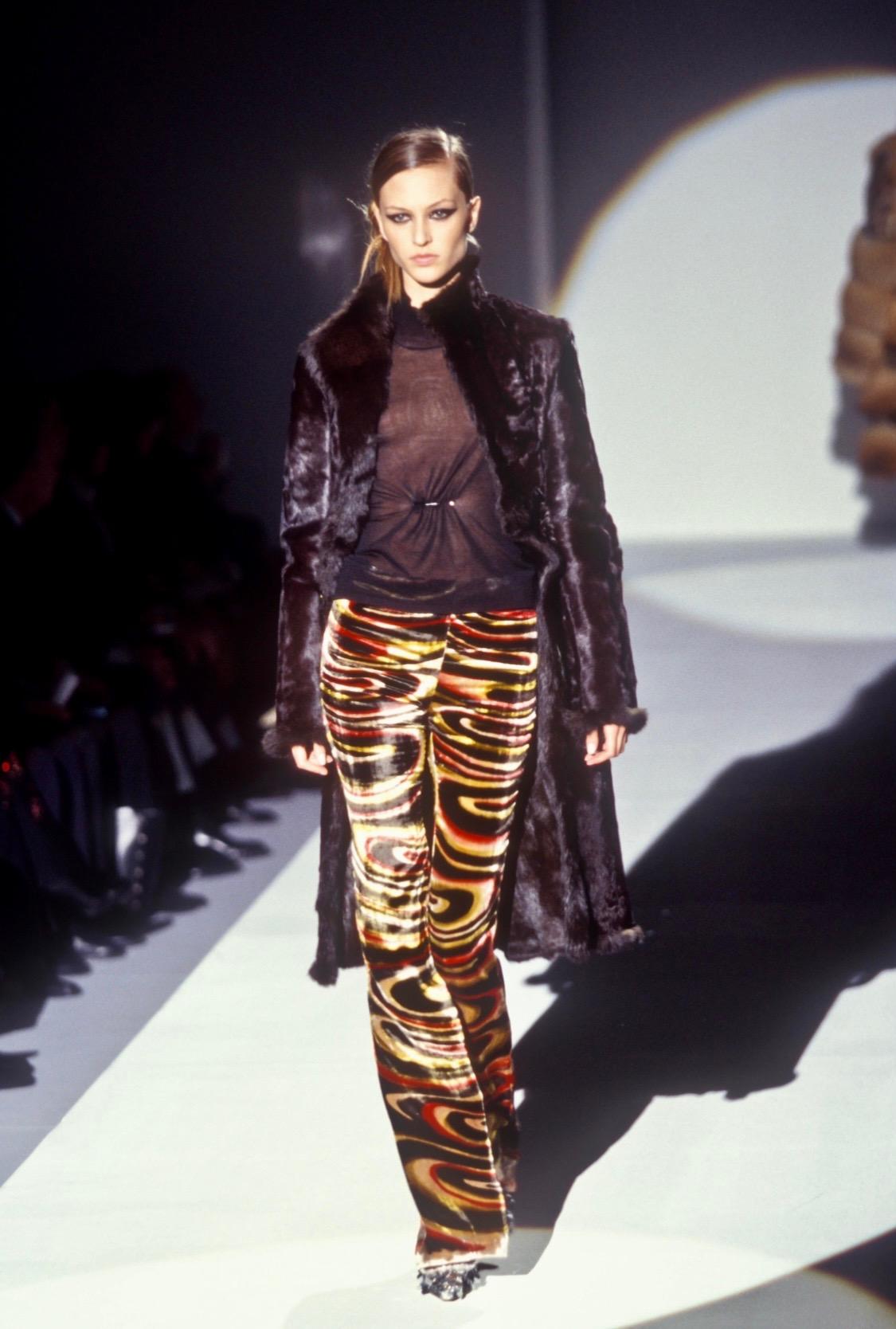 Presenting a sheer maroon short sleeve top designed by Tom Ford for Gucci's Fall/Winter 1999 collection. The front of the blouse is cinched and adorned with a silver-toned pin with G logo engraving. The black version of this top debuted on the