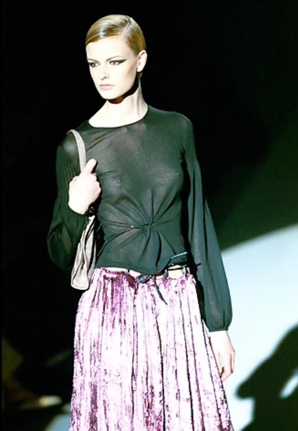 Tom Ford ha disegnato questo top in seta blu semitrasparente per la collezione Autunno/Inverno 1999 di Gucci. La versione nera di questo top a maniche lunghe ha debuttato sulla passerella della stagione. Questo top presenta maniche a campana, una