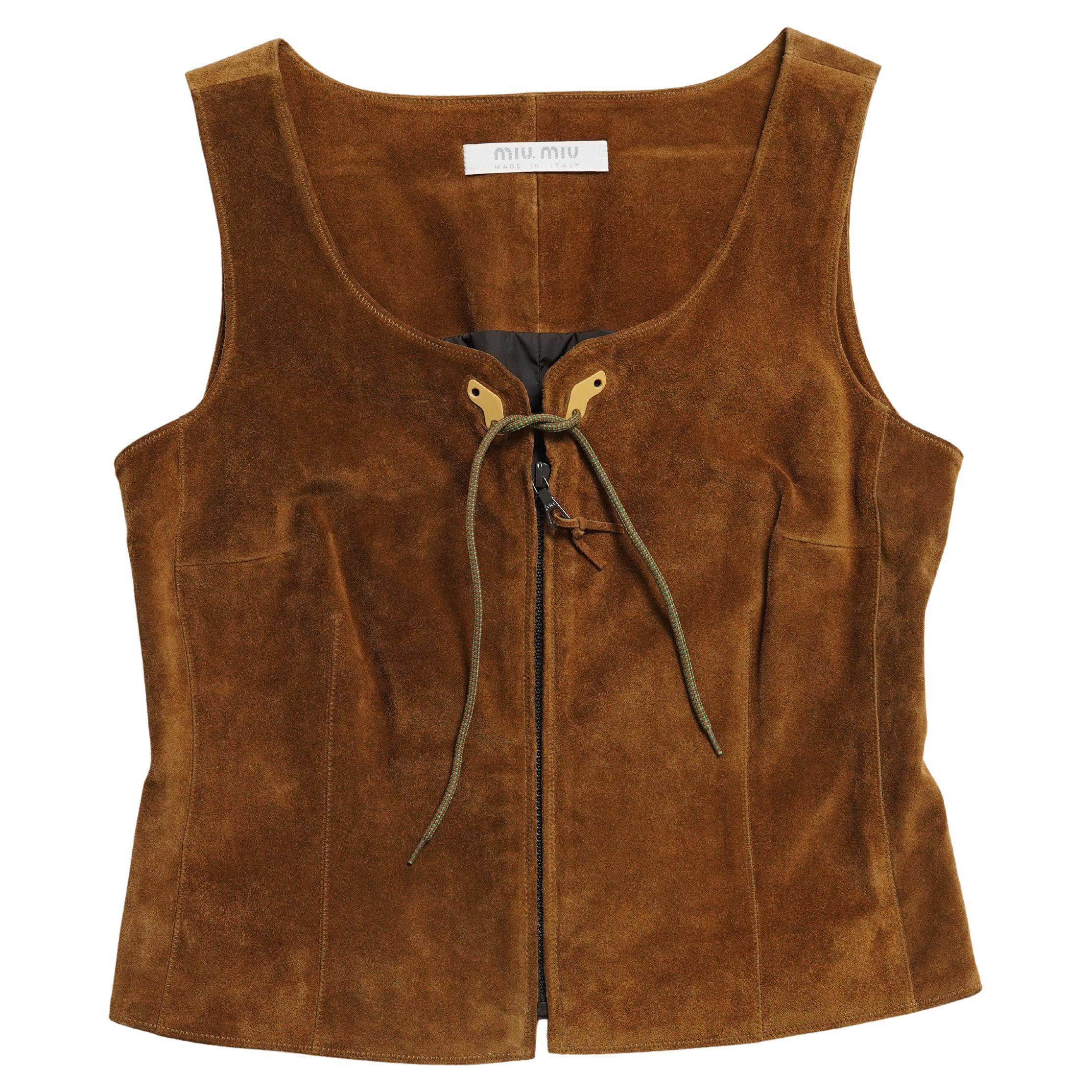 Collectional présente un corset Miu Miu F/W 1999 en cuir suédé doublé de nylon avec fermeture à glissière sur le devant, orné du ruban papillon caractéristique de la collection. À l'aube du nouveau millénaire, Miuccia Prada a continué à faire