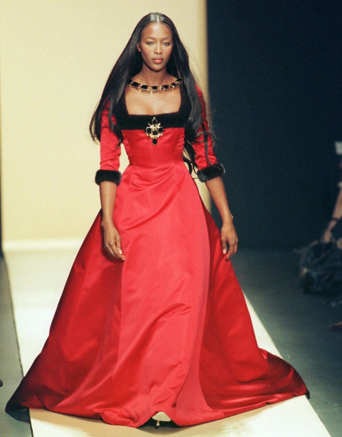 Presenting a truly incredible red silk satin Oscar de la Renta gown. From the Fall/Winter 1999 collection, this gown debuted on the season's runway modeled by Naomi Campell. This renaissance inspired dress is constructed entirely of luxurious red