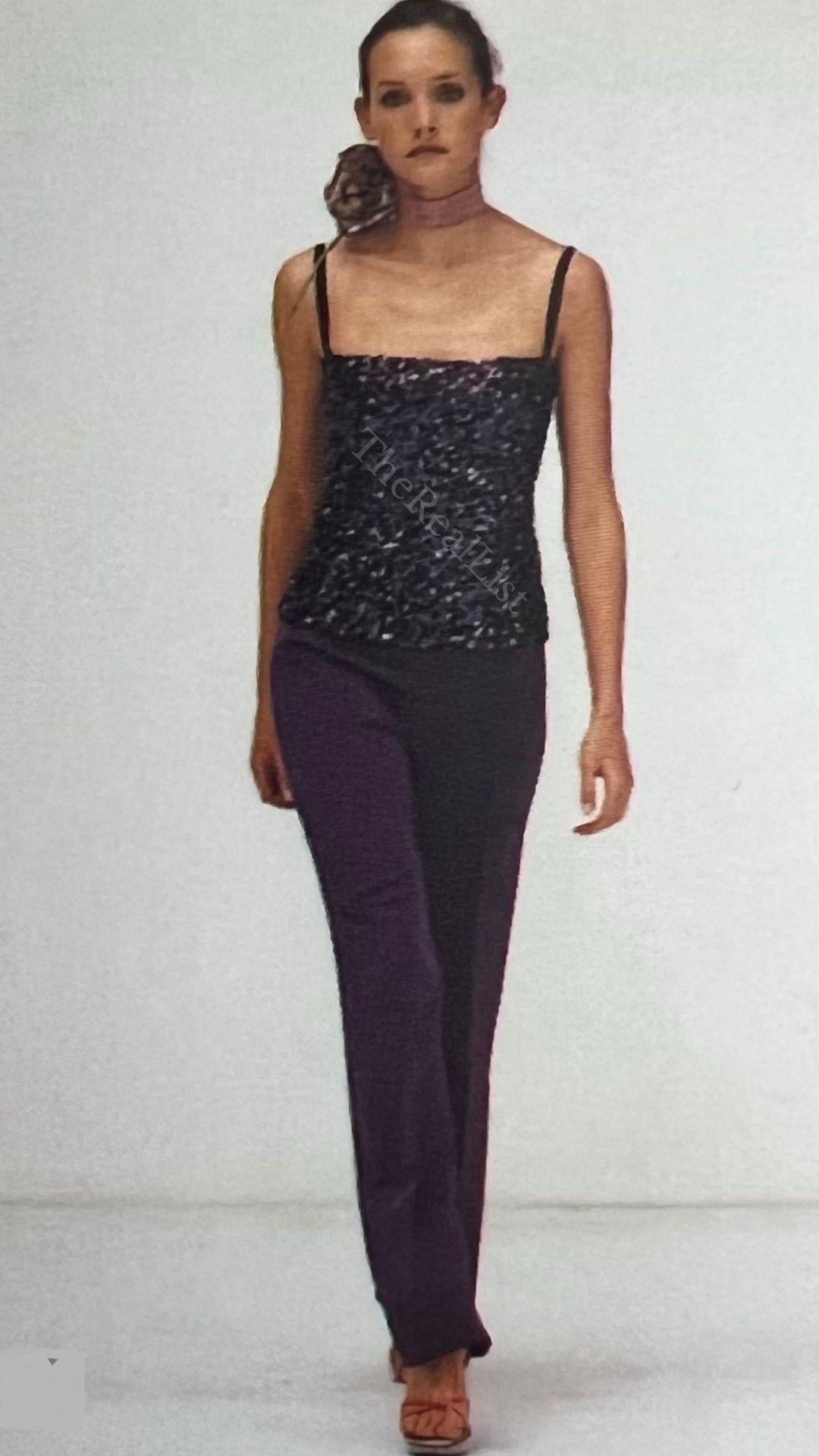 Voici un superbe top Dolce and Gabbana à paillettes violettes. Issu de la collection automne/hiver 2000, ce haut a fait ses débuts sur l'un des podiums de la saison. Ce haut fabuleusement chatoyant est recouvert de paillettes violettes, avec