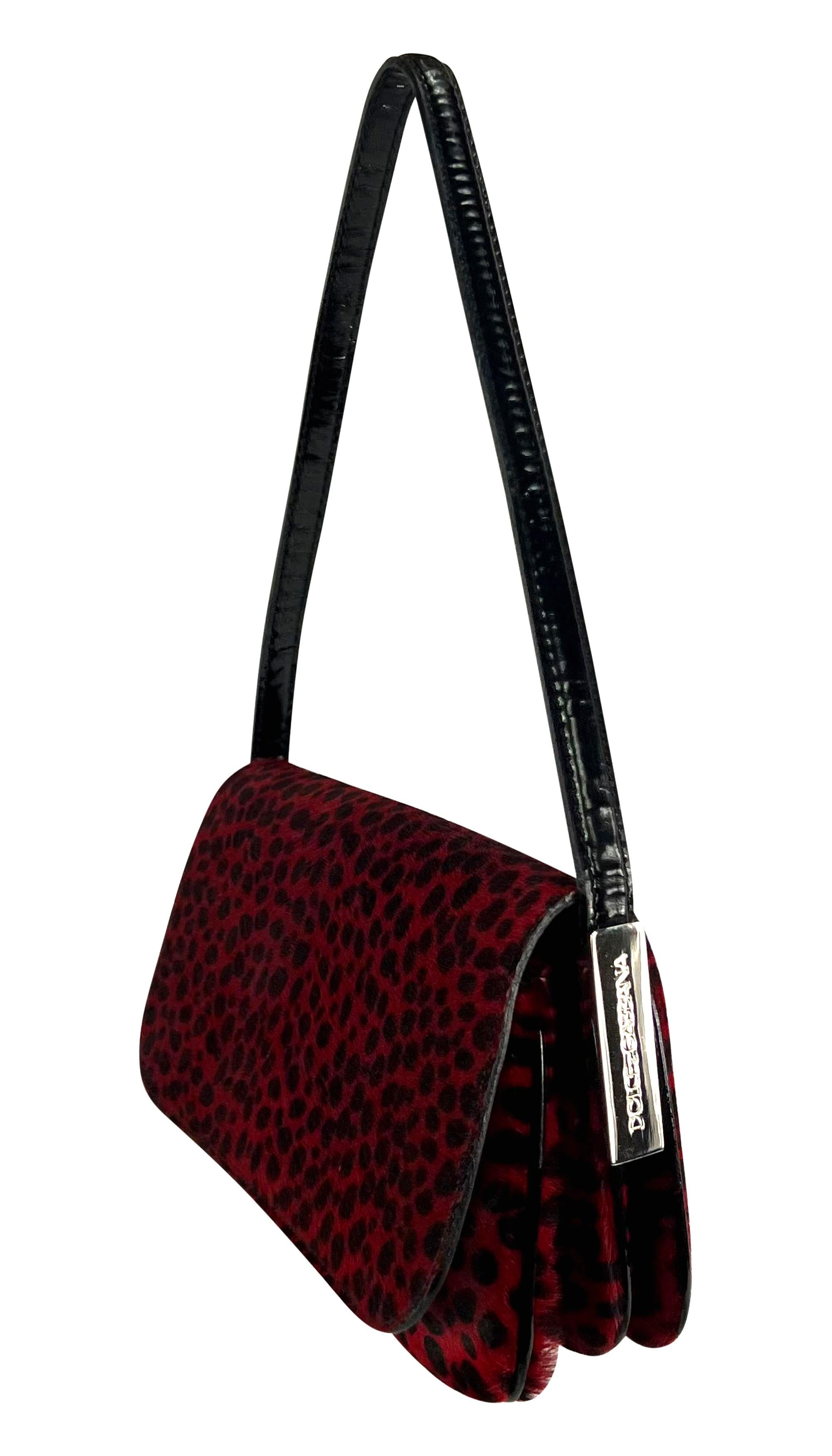 Introducing this stunning red cheetah print Dolce & Gabbana pony hair shoulder bag. Elevate your style with this exquisite piece from the Fall/Winter 2000 collection. The bag features a chic and simple design, making it a versatile accessory for any