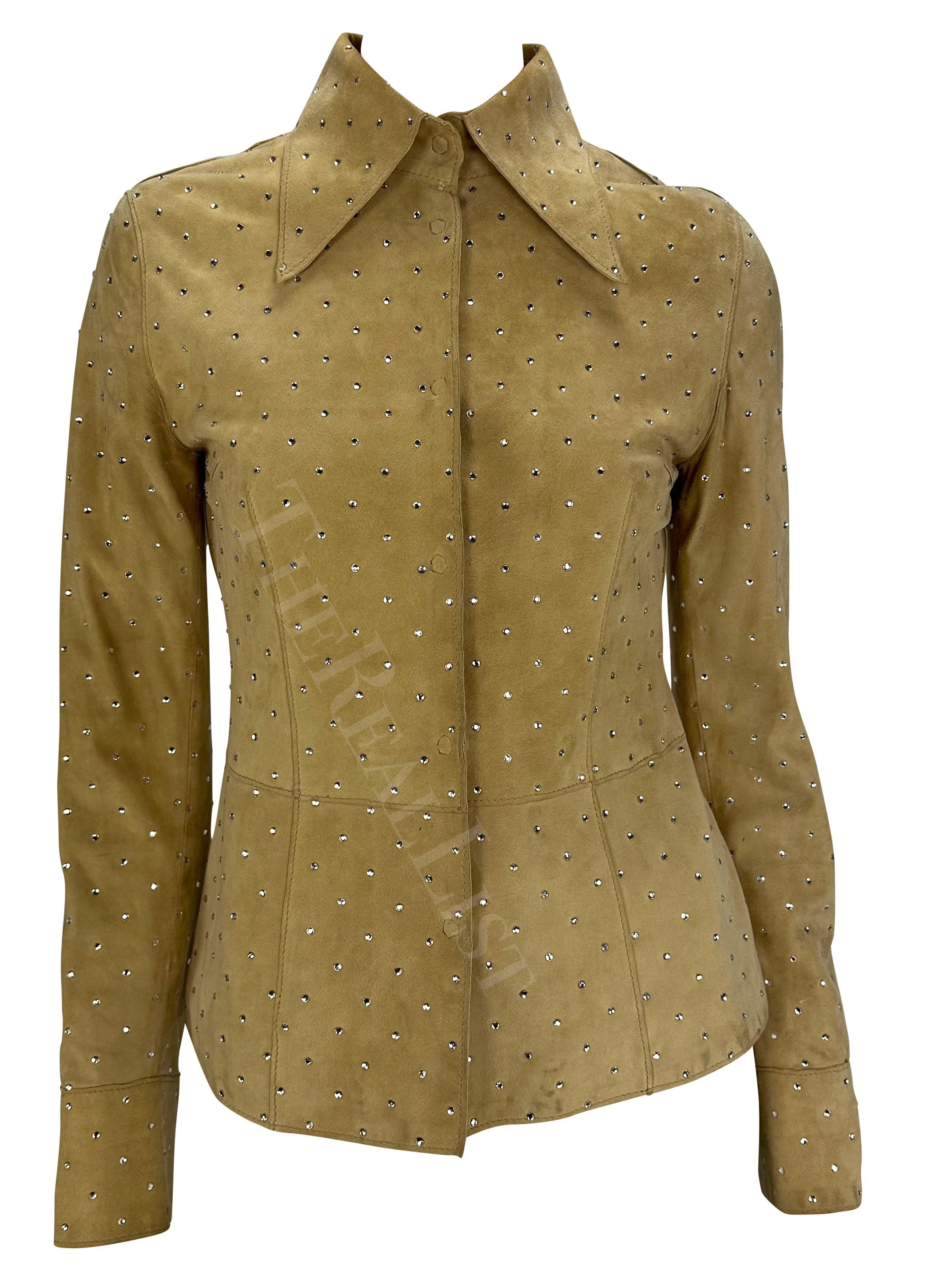 Presenting a tan suede Dolce and Gabbana collared jacket/top. From the Fall/Winter 2000 collection, this jacket is constructed entirely of suede and is accented with rhinestones throughout. Made complete with snap closures, this flashy Dolce and