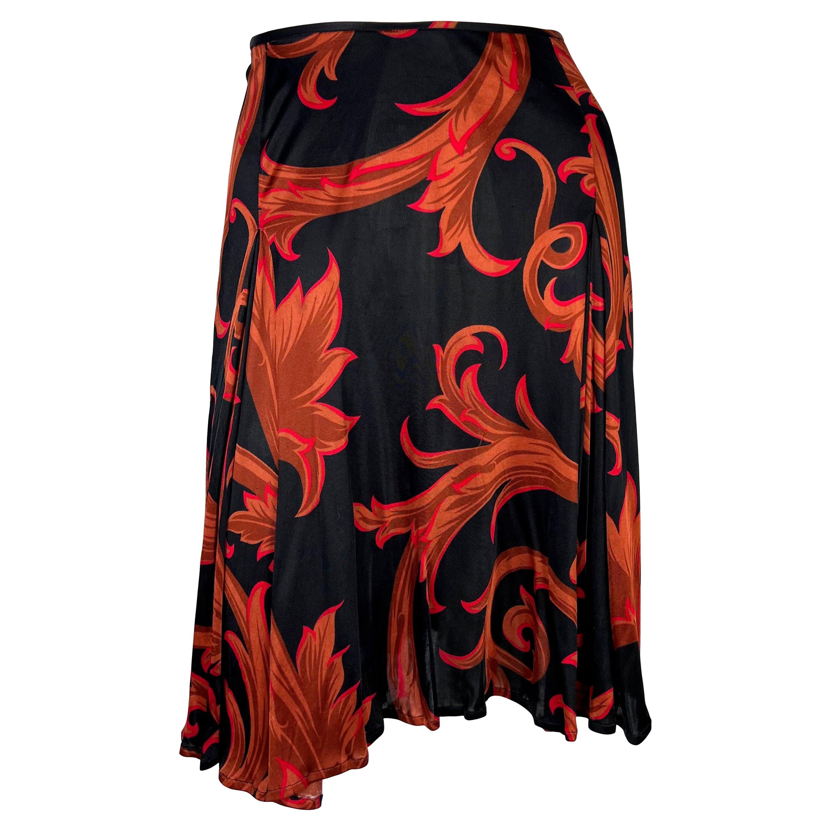 Voici une jupe Gianni Versace à imprimé baroque noir et rouge, dessinée par Donatella Versace. Issue de la collection Automne/Hiver 2000, cette jupe de style mouchoir est recouverte d'un imprimé floral baroque surdimensionné et constitue l'ajout