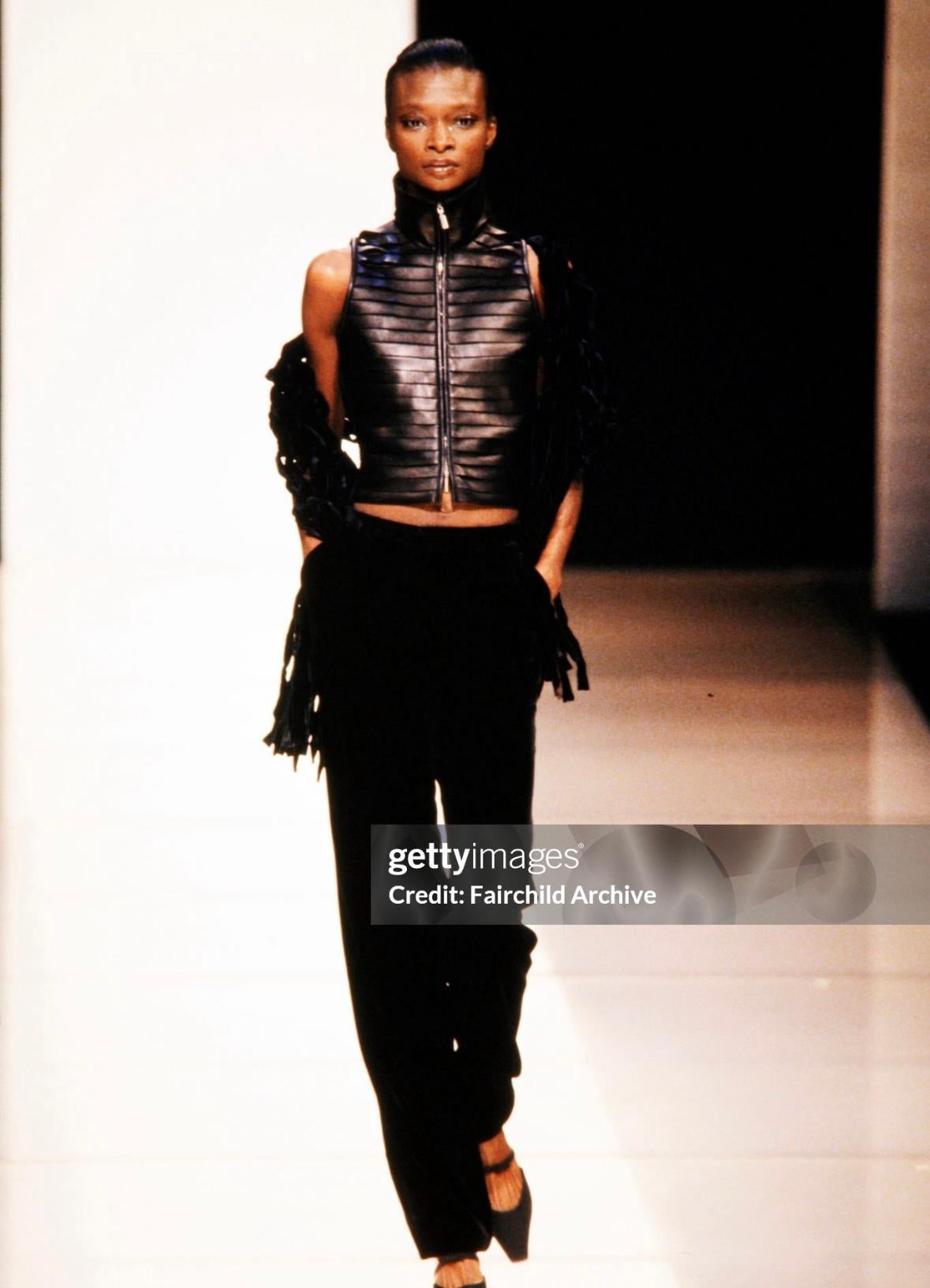 This chic Giorgio Armani strapless top from the Fall/Winter 2000 collection is made entirely of strips of black leather, similar to designs seen on the runway. The sultry tube top hugs the body and features overlapping bands of leather, a signature