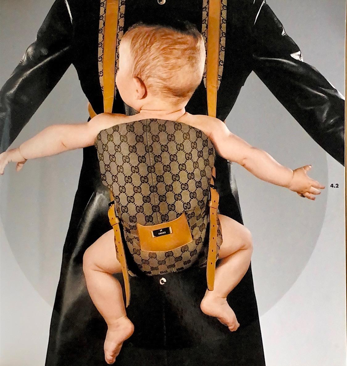 Présentation d'un rare porte-bébé conçu par Tom Ford pour Gucci, sorti dans le cadre de la collection automne-hiver 2000. Des boucles argentées à l'avant et des clips à l'arrière permettent d'ajuster facilement cette pièce. Le monogramme GG tissé