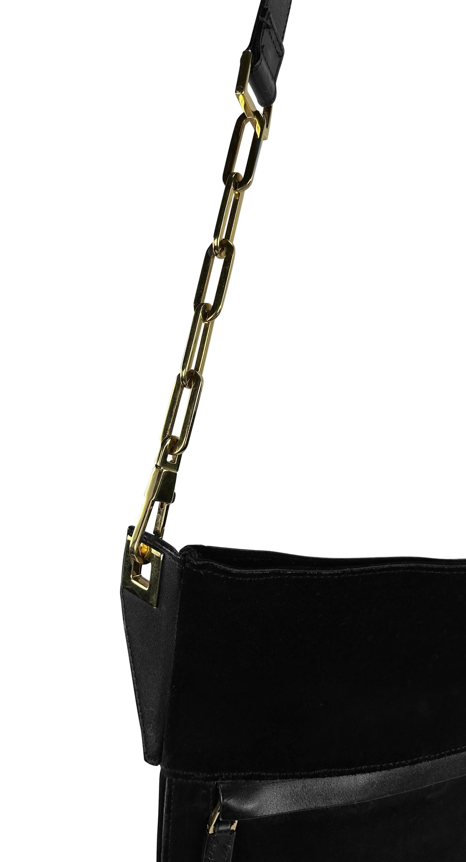 This large shoulder bag from Gucci’s Fall/Winter 2000 collection, designed by Tom Ford, is crafted from black suede. It features a flat, rectangular silhouette with a front zip pocket and an adjustable leather strap, which is connected to the bag