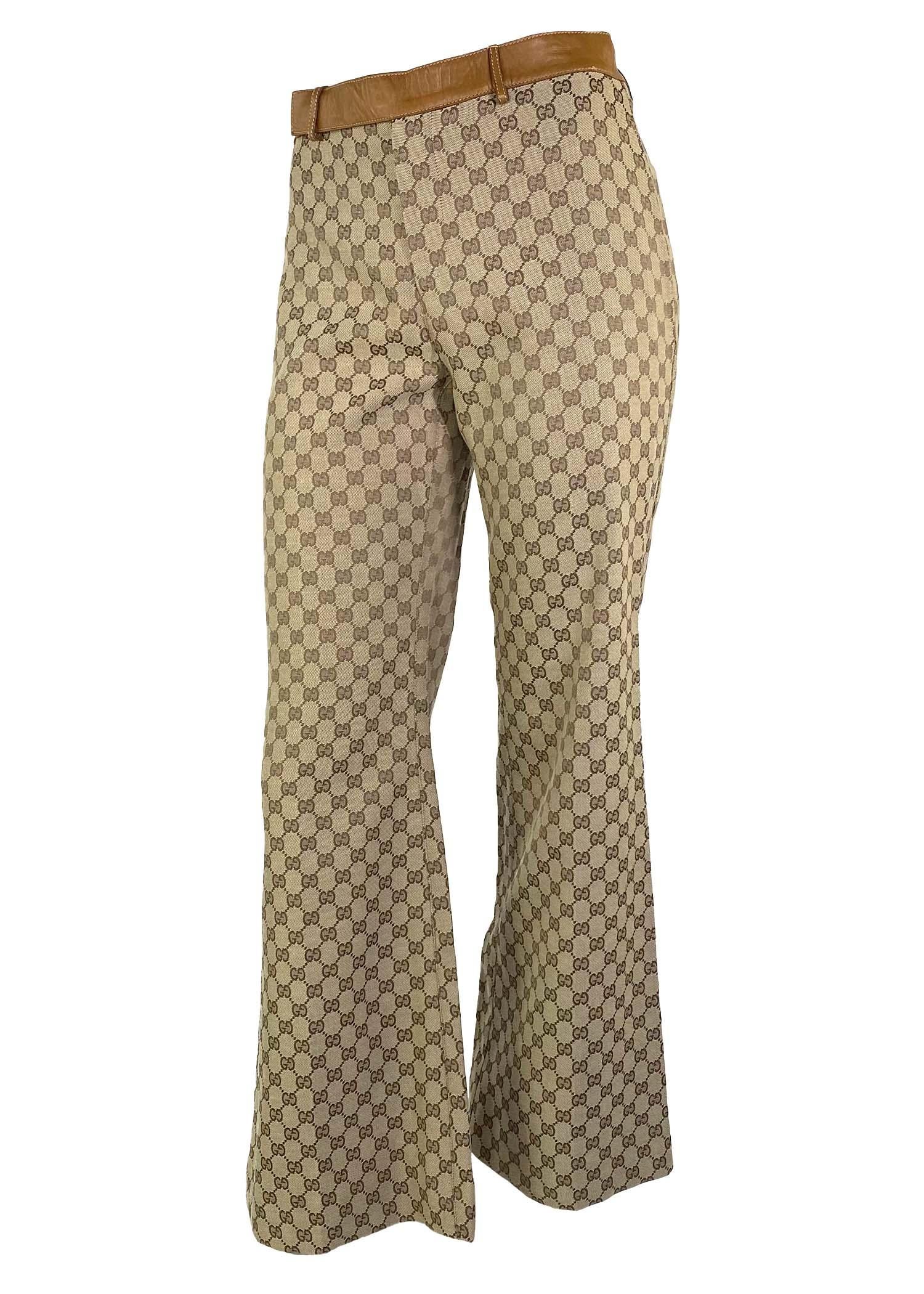 Presenting an iconic pair of 'GG' monogram Gucci canvas pants, designed by Tom Ford. This pair of wide leg pants, from the Fall/Winter 2000 collection, are constructed entirely of the classic 'GG' monogram canvas with saddle leather finishes. While