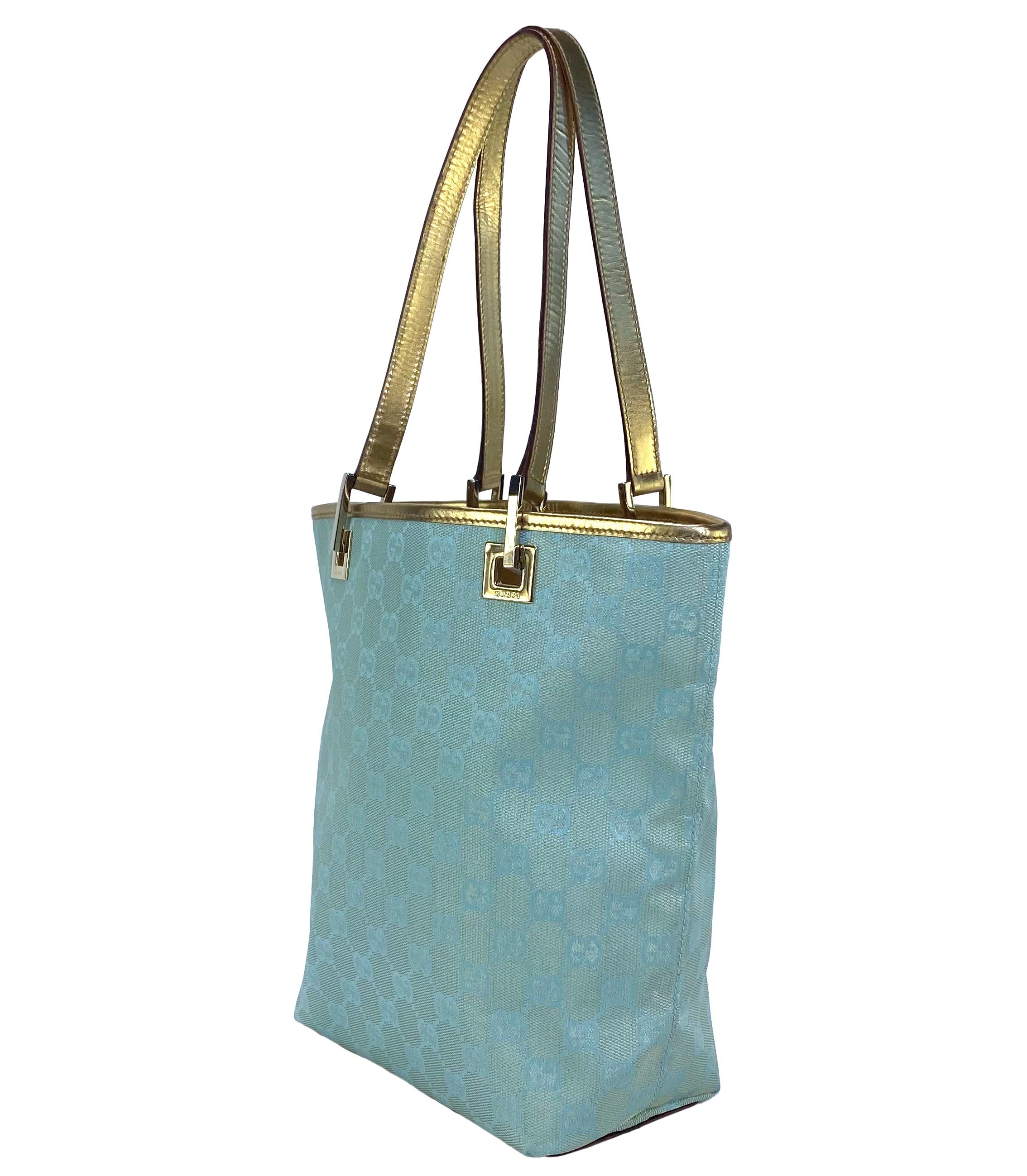 TheRealList presents: a Y2K dream Gucci bag, designed by Tom Ford. This small tote, from the Fall/ Winter 2000 collection, this bag features a light blue and gold metallic GG monogram woven canvas with gold leather trim. Perfect for everyday use,