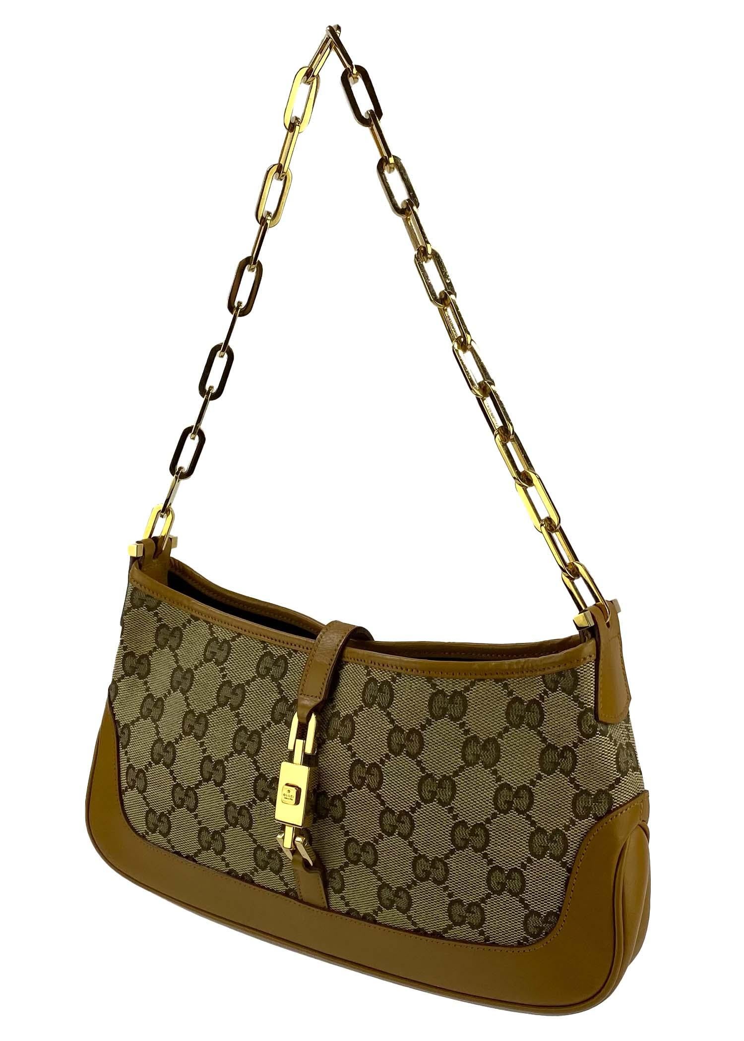 TheRealList presents: a shiny 'GG' monogram Gucci Jackie bag, designed by Tom Ford. This bag is constructed primarily of Gucci's 'GG' monogram canvas but is finished with tan leather and gold hardware. This bag, from the F/W 2000 collection, was