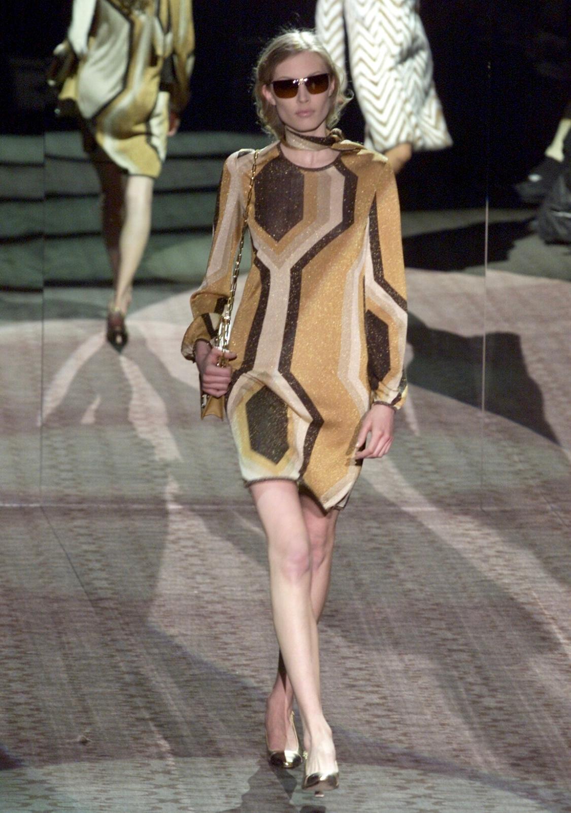 Wir präsentieren ein wunderschönes, goldfarben schimmerndes Lurexkleid von Gucci, entworfen von Tom Ford. Dieses Kleid aus der Herbst/Winter-Kollektion 2000, das auf dem Laufsteg der Saison debütierte, war der Look 32 und wurde auch auf dem Cover