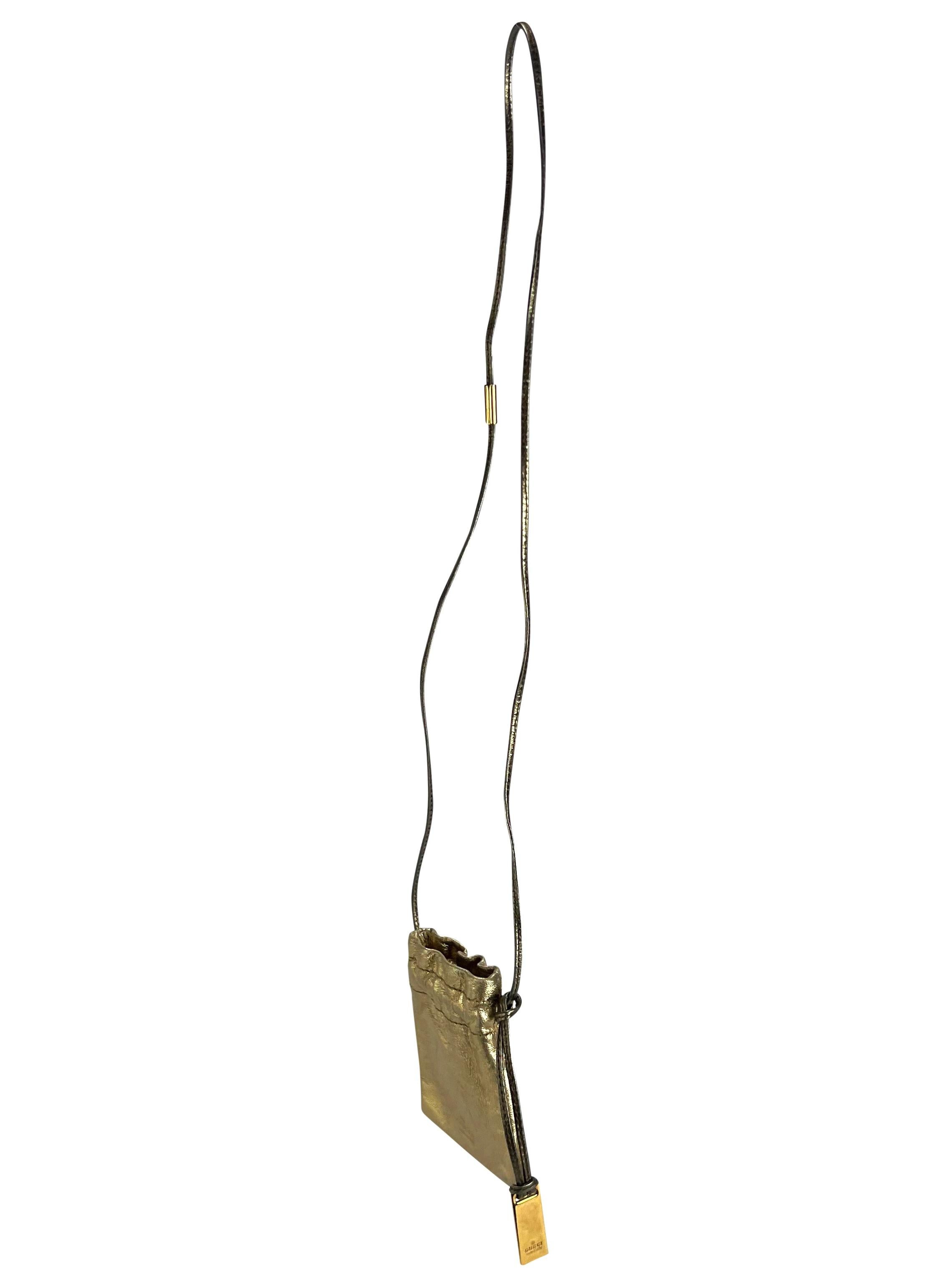 From Gucci’s Fall/Winter 2000 collection by Tom Ford, this mini pochette is crafted from gold metallic leather with a subtle logo embossing. It features a drawstring closure, a long leather crossbody strap, and a branded metal charm.

Approximate