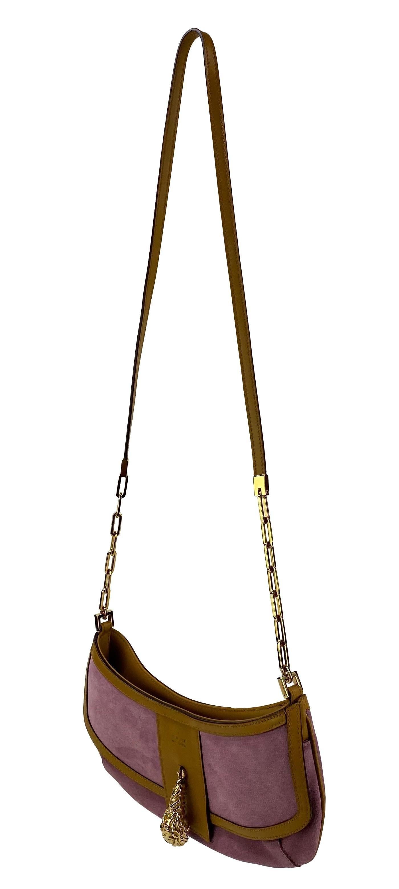 Ti presentiamo una crossbody Gucci in camoscio rosa lucido disegnata da Tom Ford. Questa borsa è realizzata principalmente in pelle scamosciata rosa, ma è rifinita con pelle marrone e finiture dorate. Inizialmente Ford ha preso un elemento classico
