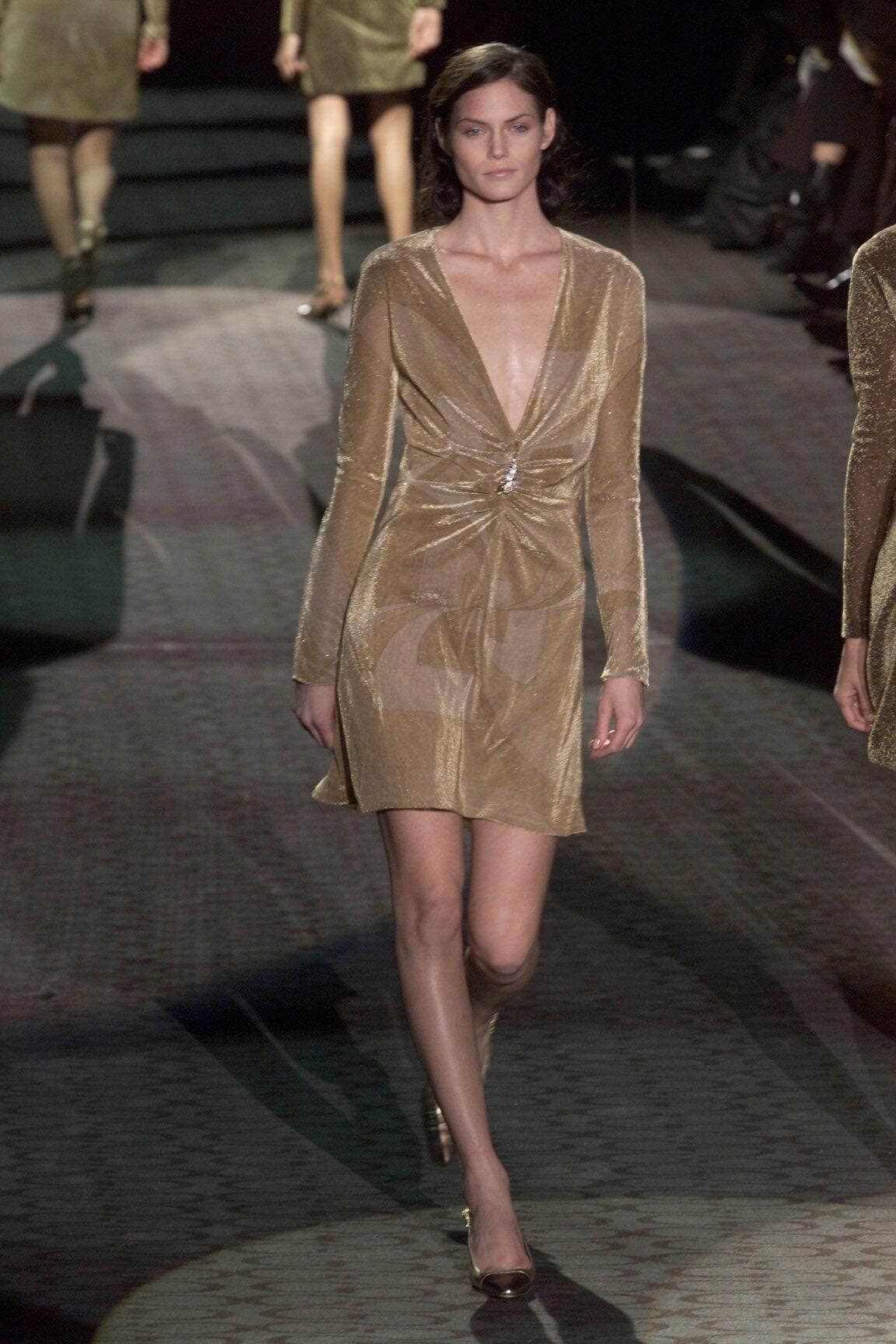 Presentamos un mini vestido dorado monocromático disco-chic brillante de Gucci diseñado por Tom Ford. Este vestido, que debutó como Look 28 en la pasarela Gucci F/W 2000 y que lució Mini Arden, brilla con luz propia. Este vestido metálico brillante