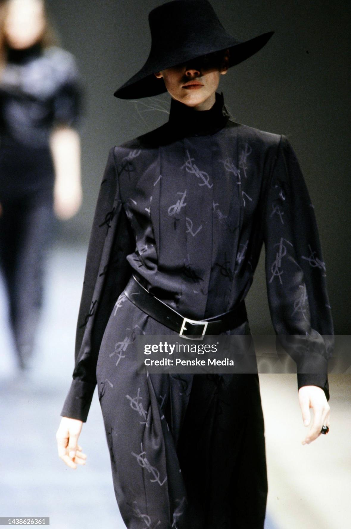 Te presentamos un precioso vestido monograma Yves Saint Laurent Rive Gauche de seda negra plisada. De la colección Otoño/Invierno 1999 de Alber Elbaz, este vestido de manga larga tiene botones ocultos en la parte delantera, cuello alto, mangas
