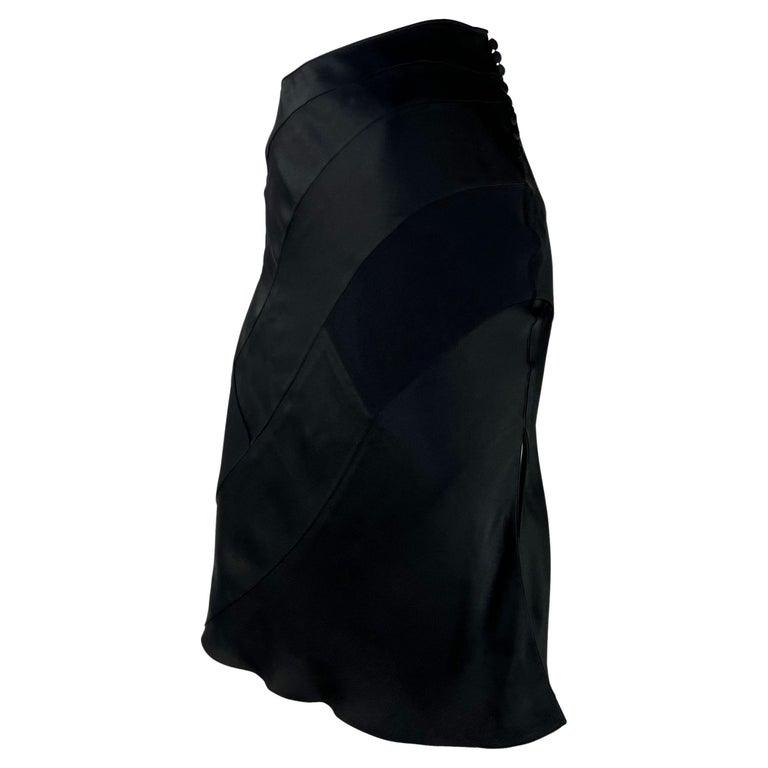 TheRealList presents: a fabulous black satin panel Christain Dior Boutique skirt, designed by John Galliano. From the Fall/Winter 2001 collection, this skirt is constructed of black silk satin panels and is made complete with a row of button