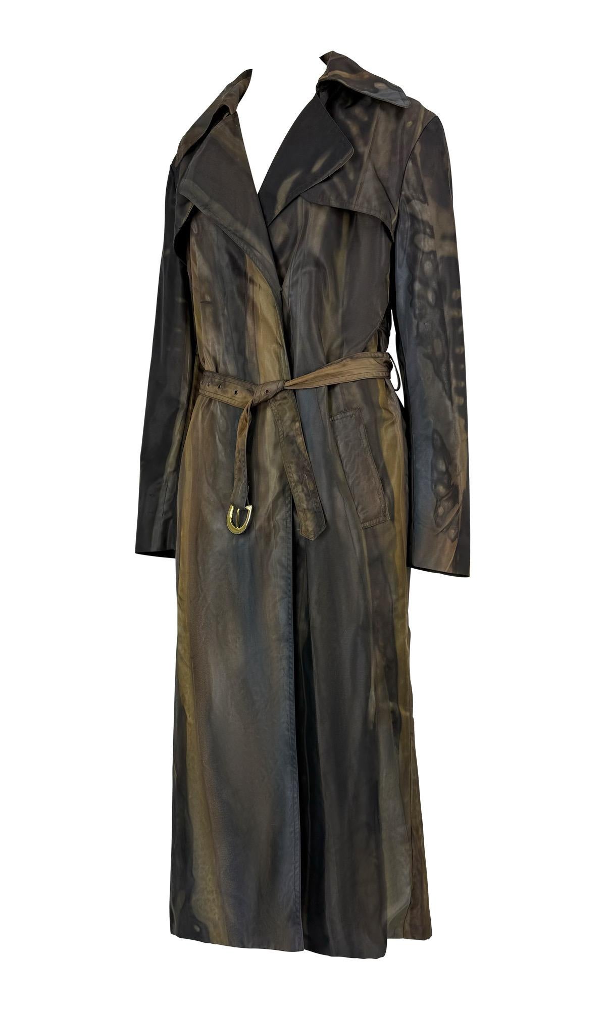 This Christian Dior brown nylon coat from Fall/Winter 2001, designed by John Galliano, features an abstract watercolor effect. The lightweight design is defined by trench coat stylings, a belted waist, and its fluid pattern. 

Approximate
