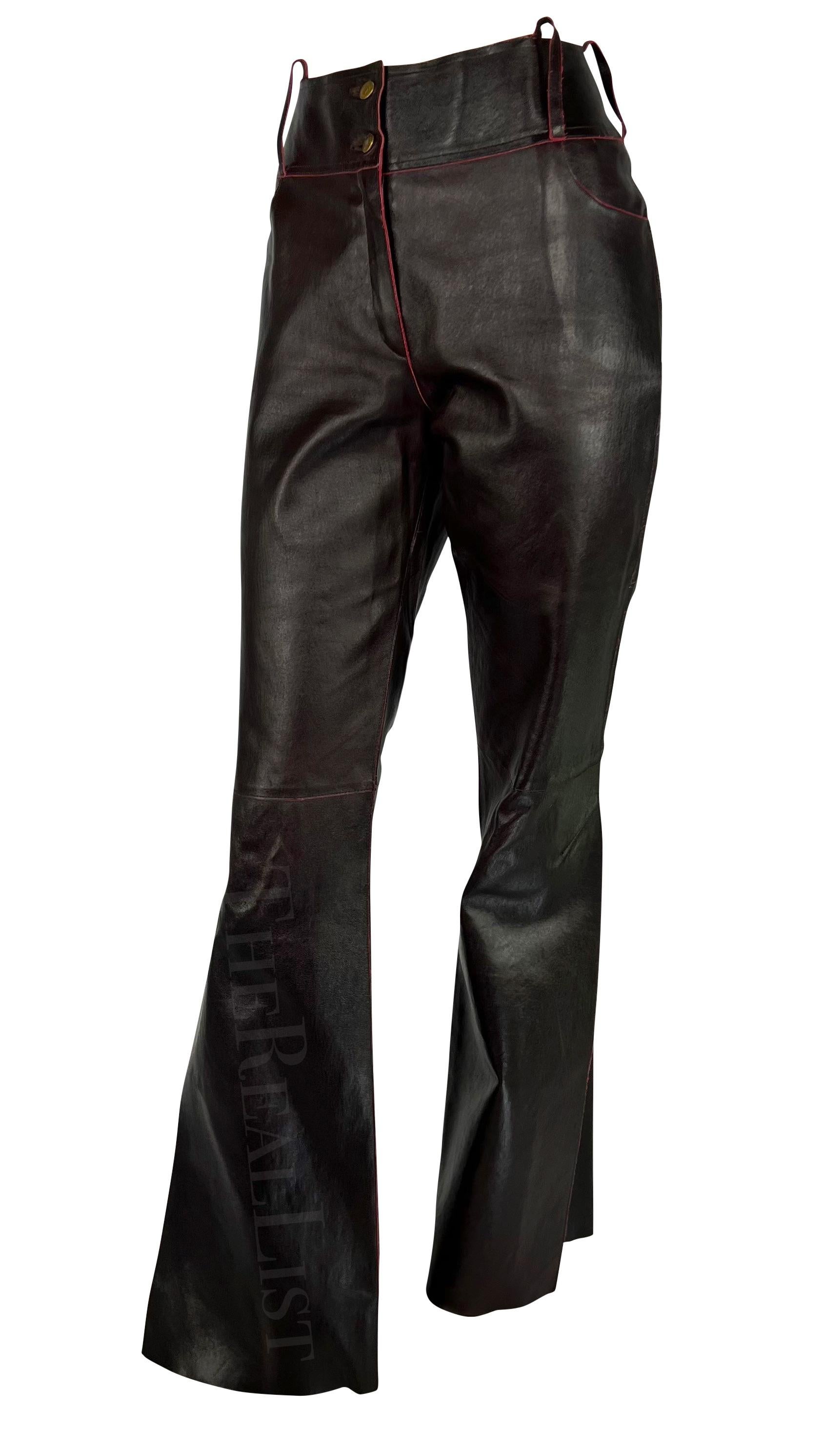 Presenting a fabulous pair of brown/red leather Christian Dior pants, designed by John Galliano. From the Fall/Winter 2001 collection, these pants are constructed entirely of brown leather with red undertones that are highlighted when the pants