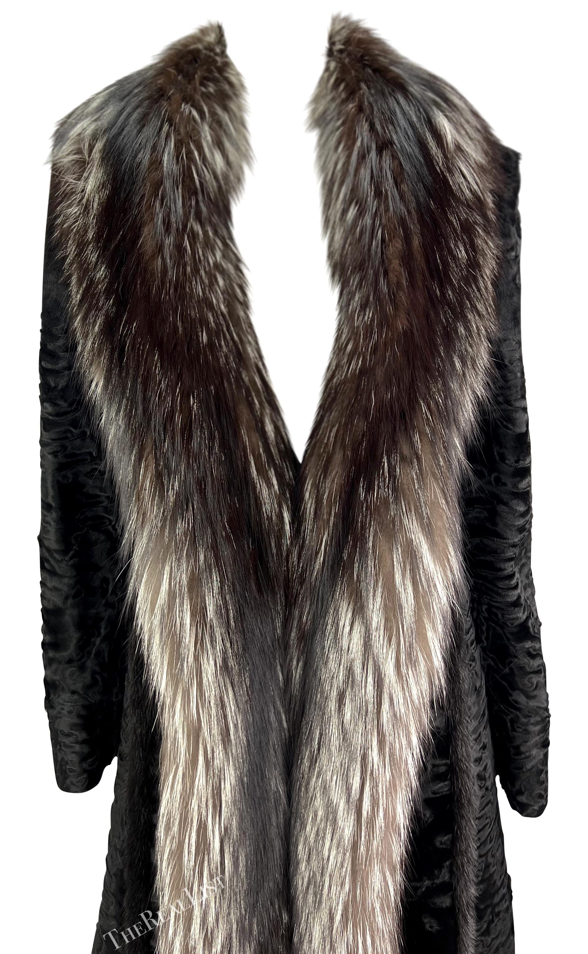 This luxurious full-length Gianni Versace coat from the Fall/Winter 2001 collection, designed by Donatella Versace, is crafted from black astrakhan fur with an opulent silver fox fur trim along the collar and front opening. The design includes mink