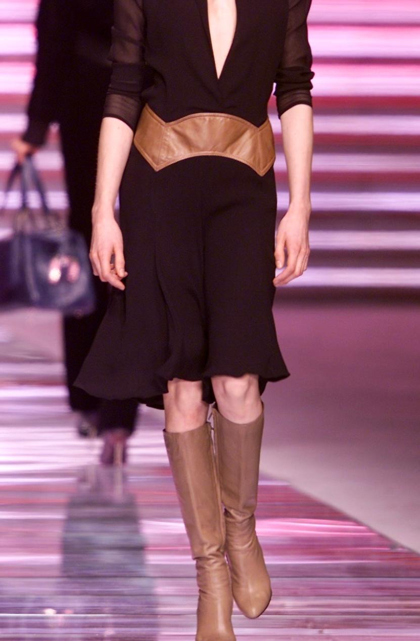 This stunning saddle brown Gianni Versace skirt with leather accents, was designed by Donatella Versace. From the Fall/Winter 2001 collection, similar styles and leather accented pieces were highlighted on the season's runway. This knee-length