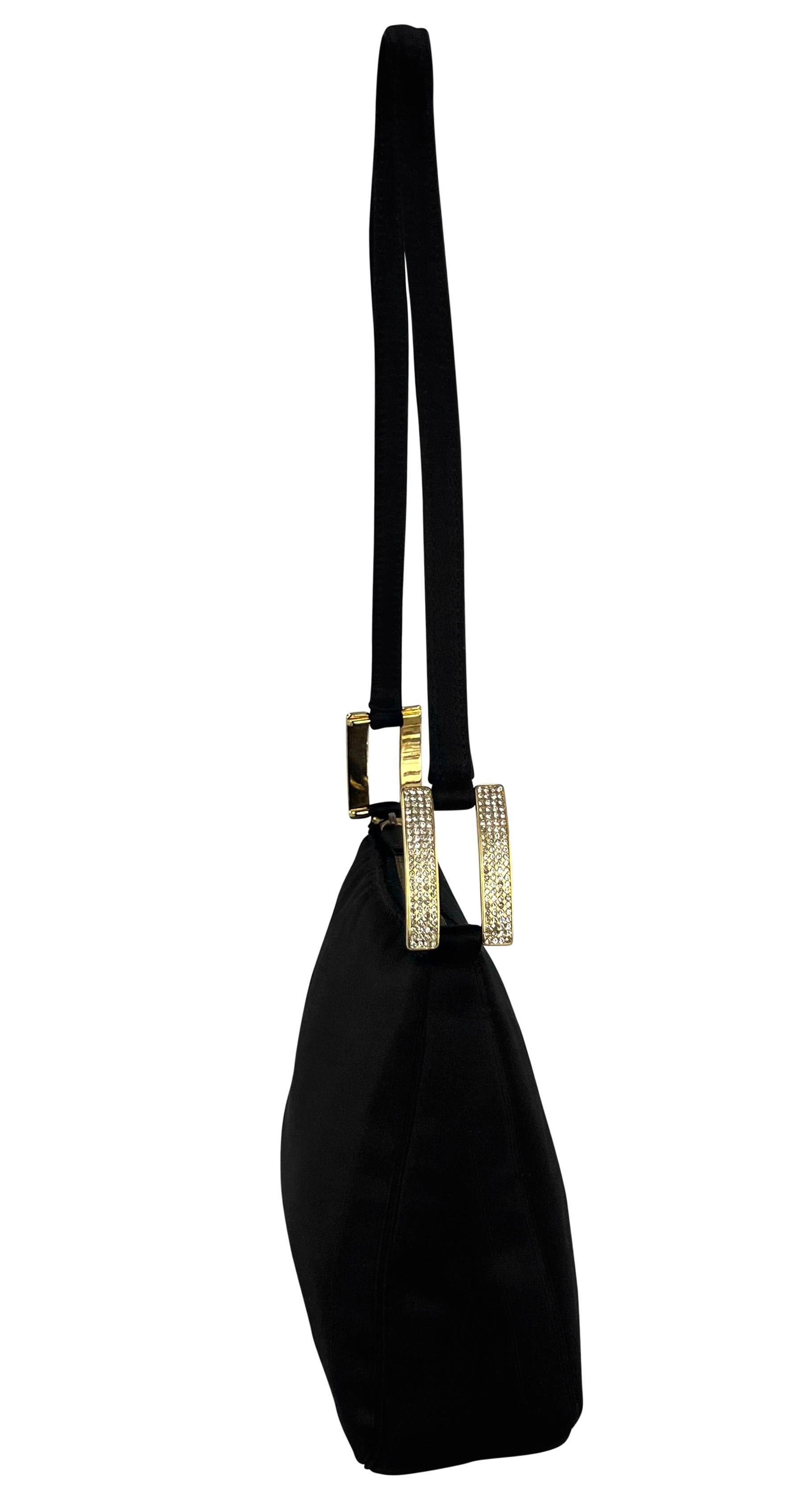 Donatella Versace designed this elegant black satin evening bag for the Fall/Winter 2001 Gianni Versace collection. This charming mini bag features a sleek satin body with straps connected by angular gold-tone hardware, accented with rhinestones for
