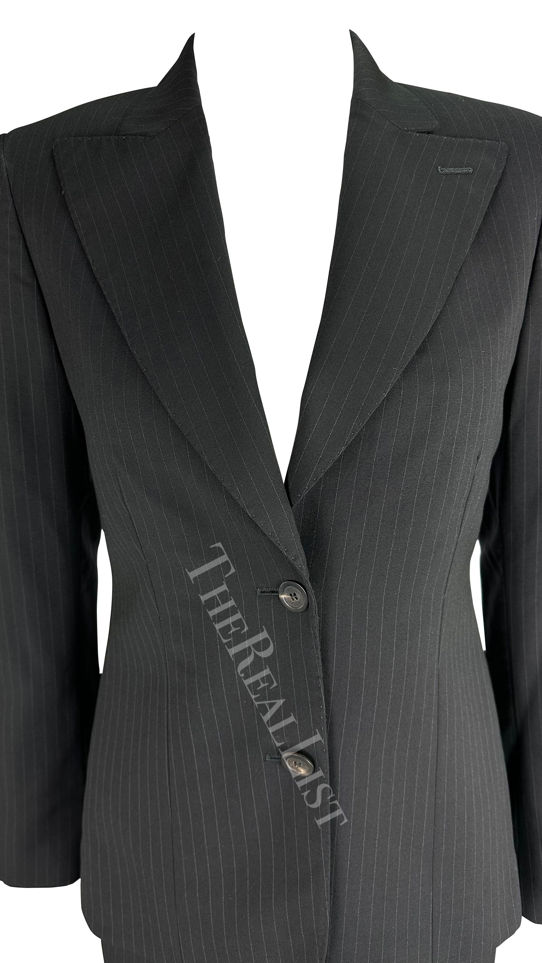 Presenting a fabulous black Gucci pinstripe suit, designed by Tom Ford. From the Fall/Winter 2001 collection, this chic suit is constructed of a wide lapel blazer and matching wide-leg pants. Perfect for your next board meeting or night