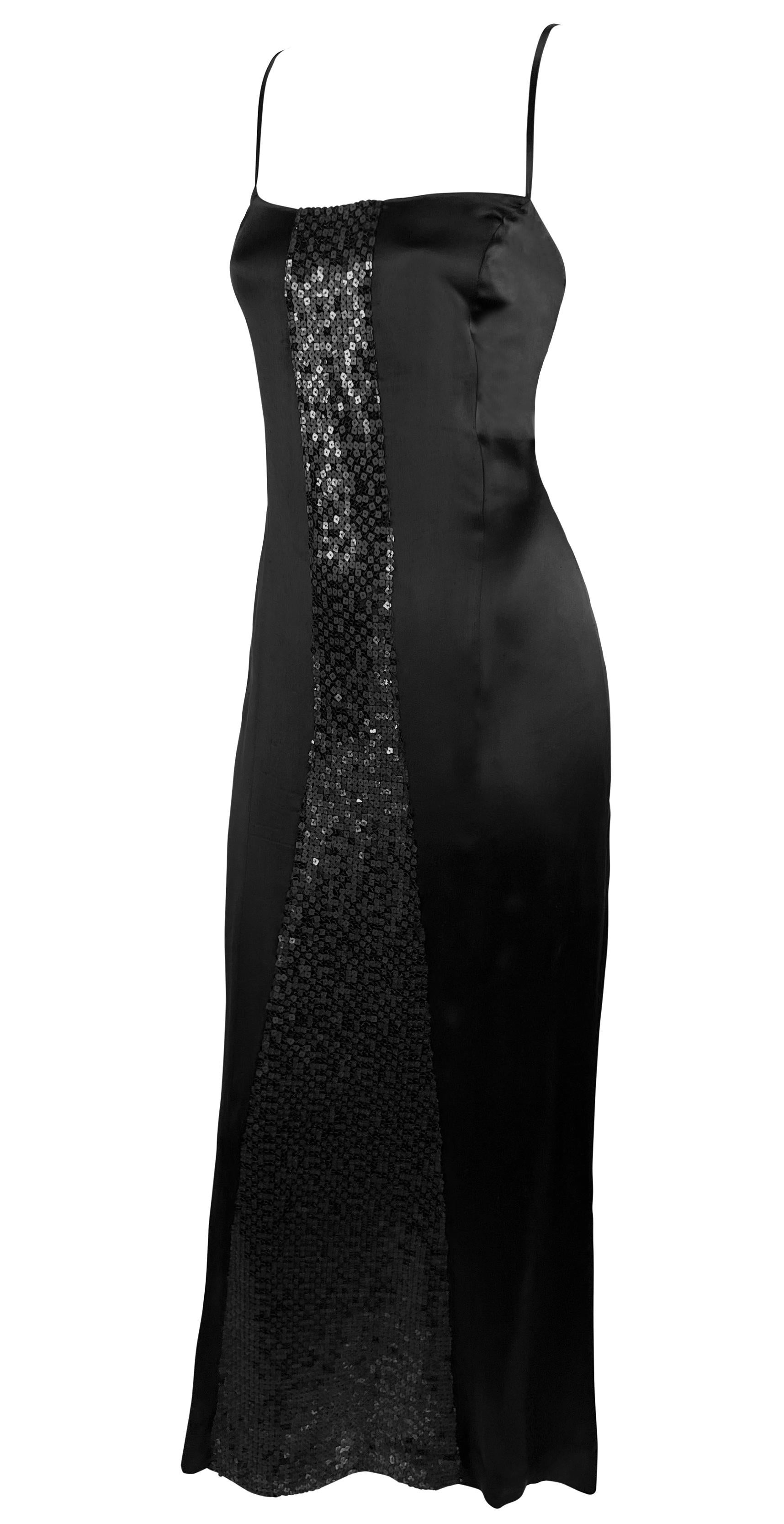 Karl Lagerfeld designed this chic black gown for his Fall/Winter 2002 collection at Chanel. This sexy silk satin slip dress features a square neckline, spaghetti straps, and an ankle-length hem. This stunning satin dress is complete with a panel of