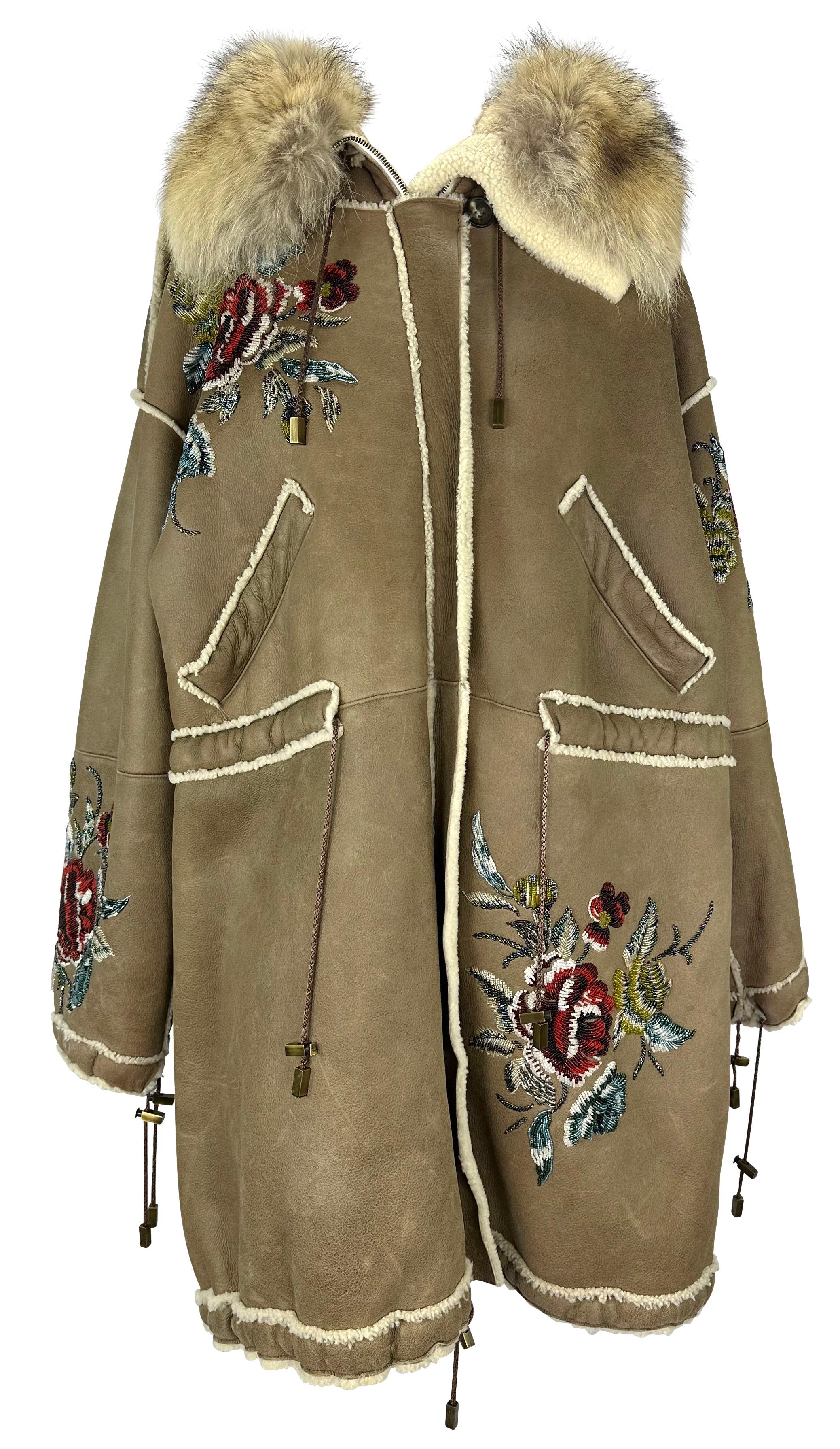 This incredible tan shearling and fur Christian Dior oversized coat, designed by John Galliano. From the Fall/Winter 2002 collection, this oversized coat is constructed entirely of shearling and is made complete with a coyote fur trimmed hood. The