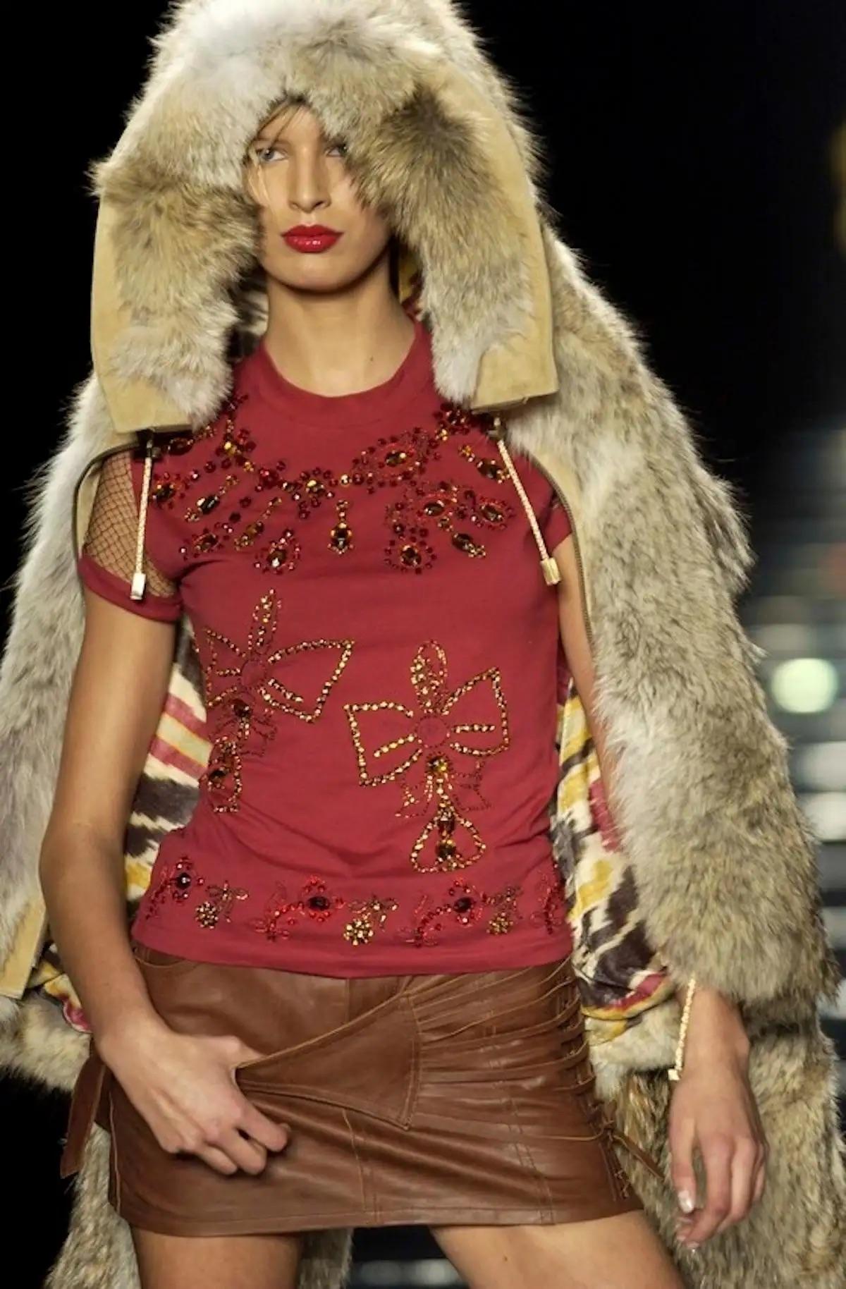 John Galliano designed this Christian Dior brown leather mini skirt for the Fall/Winter 2002 collection. Constructed entirely of leather, this short skirt debuted on the season's runway and features a lace-up accent at one side that juts into