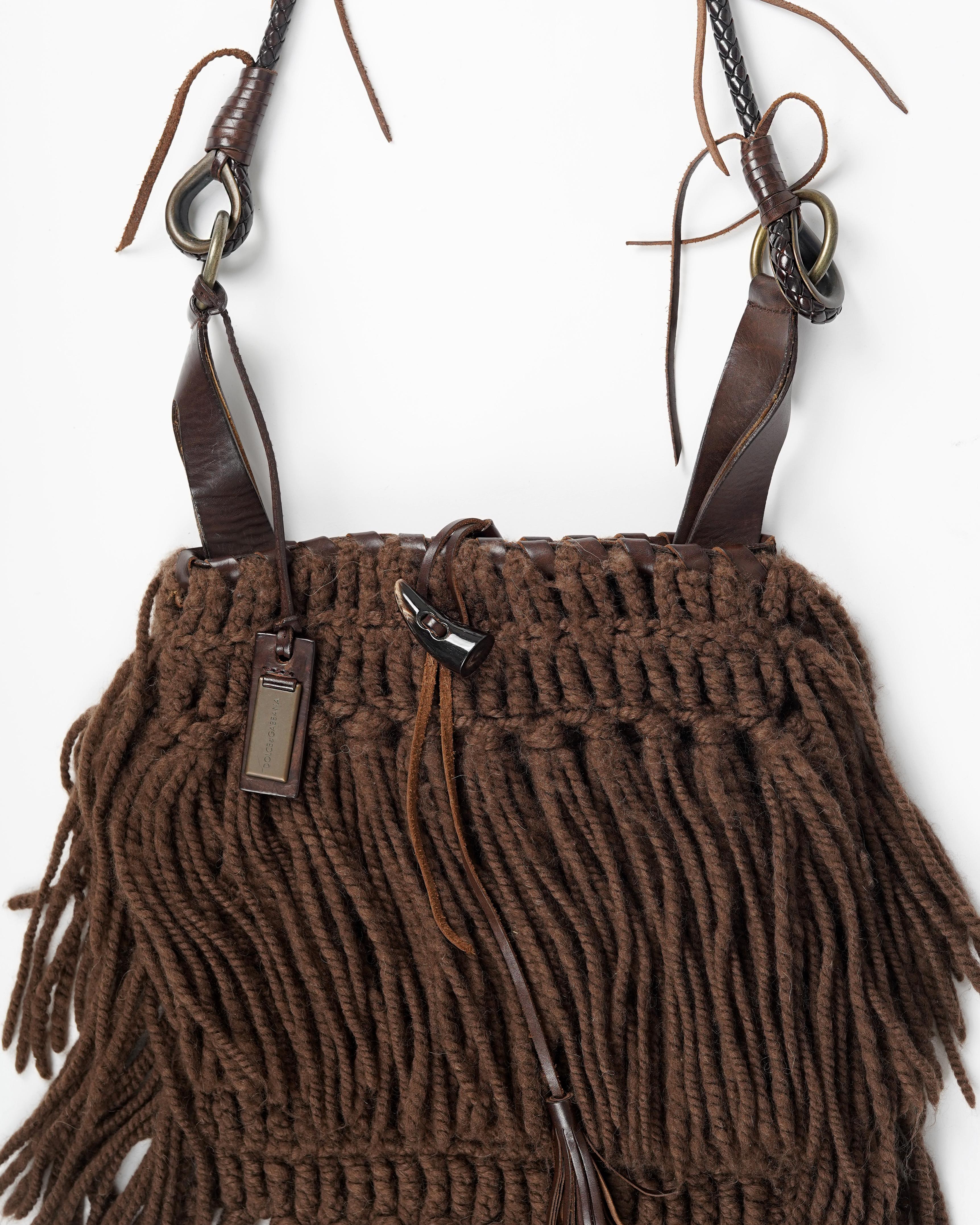 Presenting a rare F/W 2002 Dolce&Gabbana Runway fringe bag. The bag is constructed of knurled wool fringes, brown suede leather lining and is made complete with brass rings set in leather along the partly braided shoulder strap. The enamelled