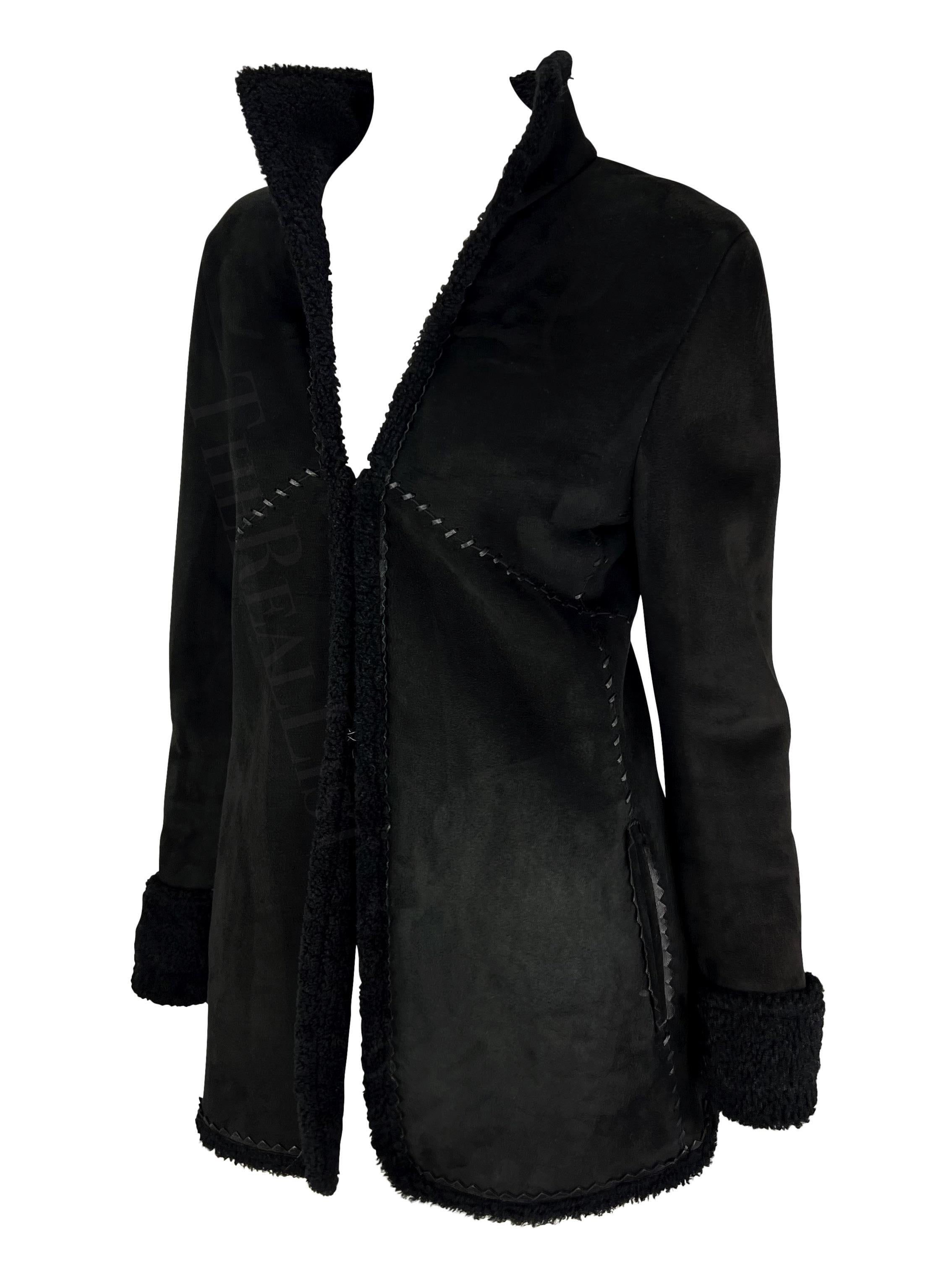 Ich präsentiere einen schwarzen Gianni Versace Mantel aus Shearling, entworfen von Donatella Versace. Dieser Mantel aus der Herbst/Winter-Kollektion 2002 ist außen aus Wildleder und innen aus Shearling. Das Shearling-Fell kann an den Manschetten