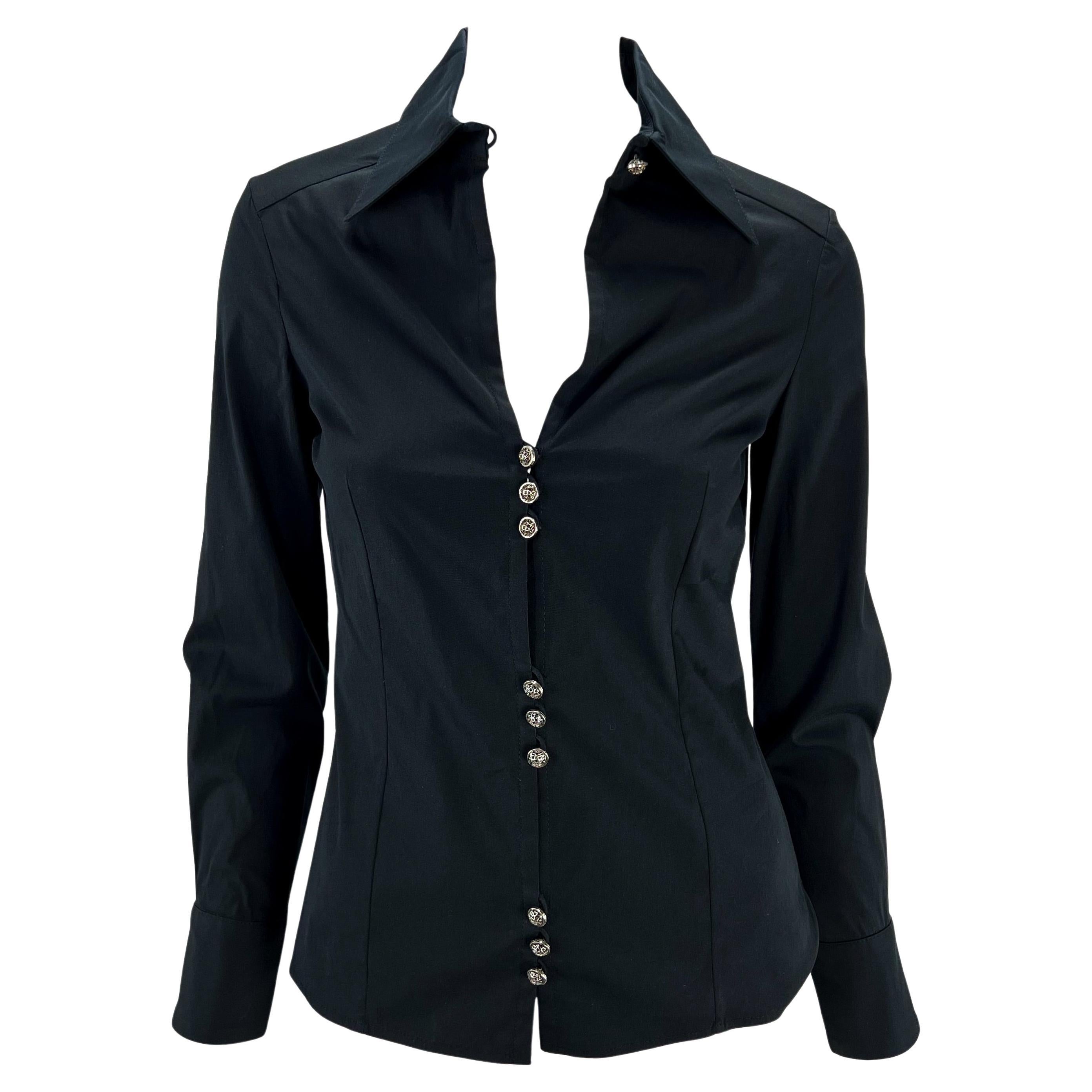Ti presentiamo un sexy top nero con colletto di Gianni Versace Couture, disegnato da Donatella Versace. Dalla collezione Autunno/Inverno 2002, questo top aderente con bottoni presenta una scollatura profonda e tre gruppi di bottoni argentati sulla