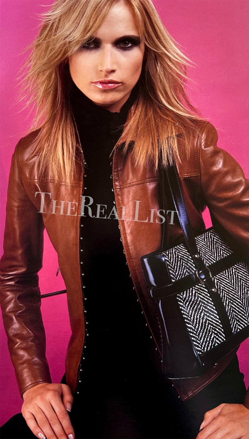 Presenting a sleek black Gianni Versace leather jacket designed by Donatella Versace for the Fall/Winter 2002 season. This collared leather jacket features a row of hook and eye closures down its front. This unique closure leaves the perfect peak of