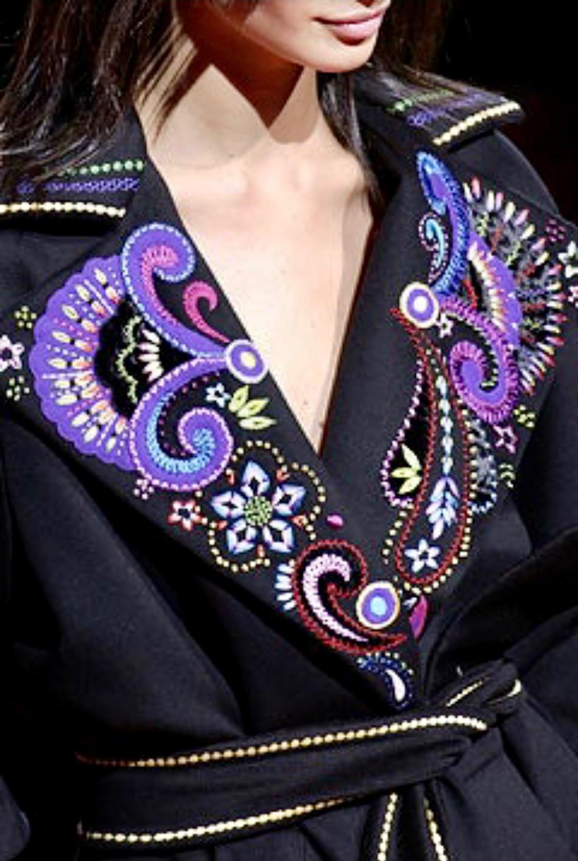 Présentation d'un mini sac en velours matelassé strassé et brodé conçu par Donatella pour Gianni Versace. Les poignées sont en satin de soie noir et s'harmonisent parfaitement avec la quincaillerie dorée, également recouverte de strass. Cette pièce,