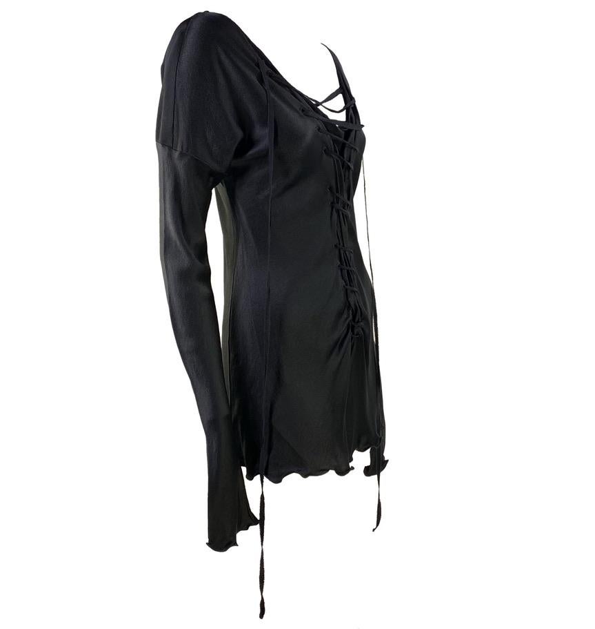 Presenting a punk rock goth inspired Gucci mini dress, designed by Tom Ford. From the Fall/Winter 2002 collection, this silk dress features a lace up center and bell sleeves. Both the hem and the cuffs feature a slight ruffled flare. One of Tom