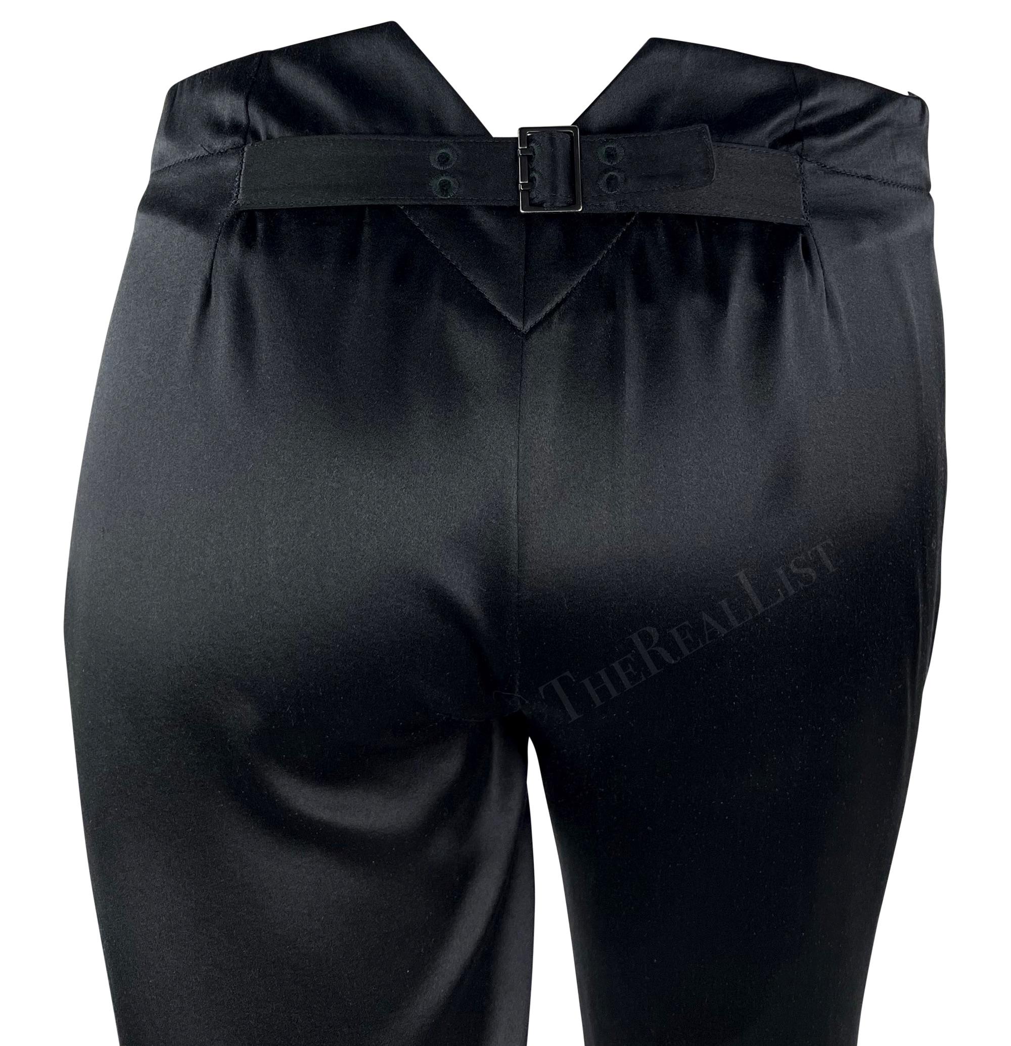 These black silk pants are designed by Tom Ford for Gucci, from the Fall/Winter 2002 collection. Made from luxurious satin, they are tapered with a distinctive v-shaped cut at the back, where you'll find an adjustable buckle for a perfect