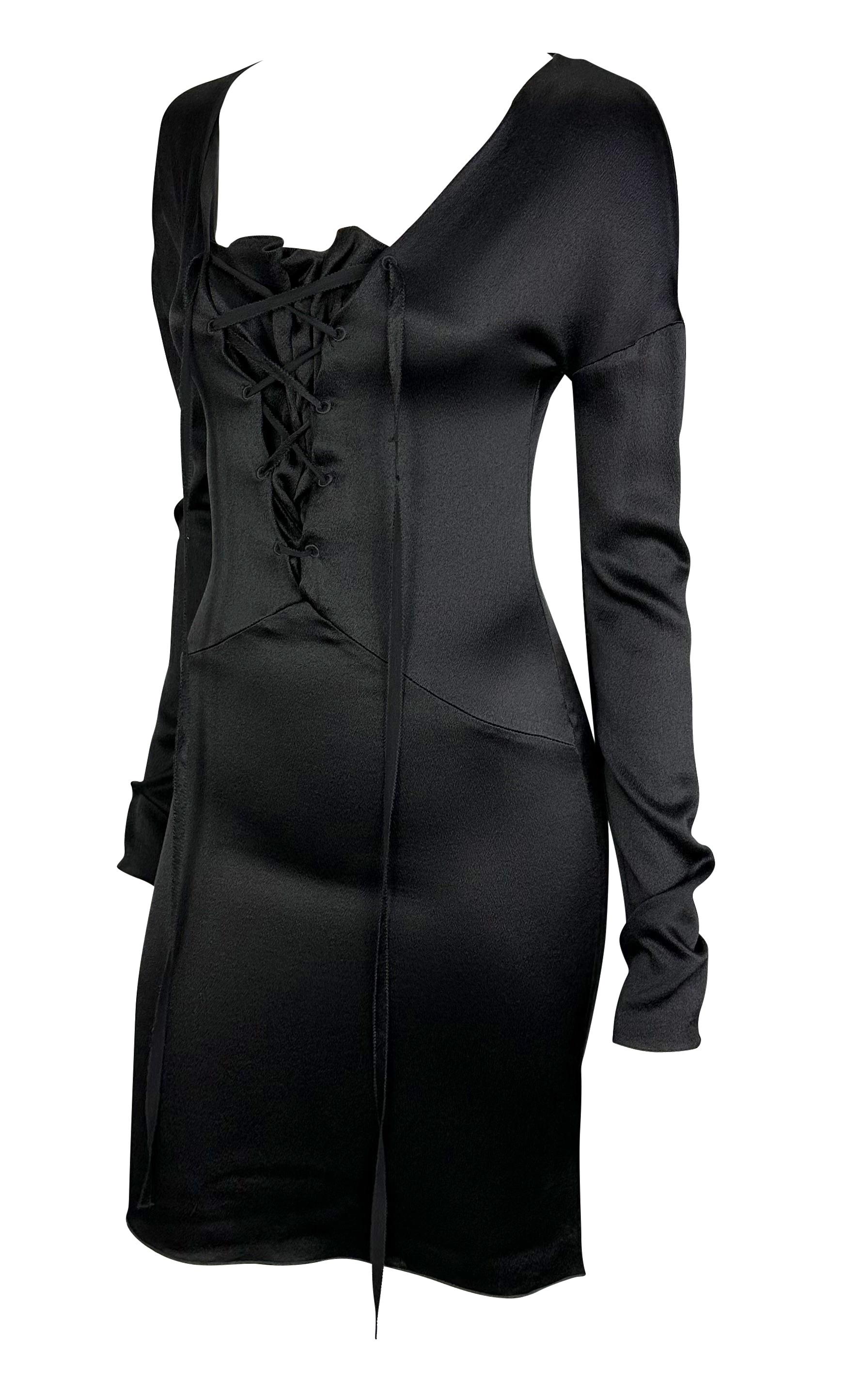 Presenting a punk rock goth-inspired Gucci mini dress designed by Tom Ford. From the Fall/Winter 2002 collection, this silk dress features a lace-up center and long sleeves. Both the hem and the cuffs feature a slight flare. One of Tom Ford's