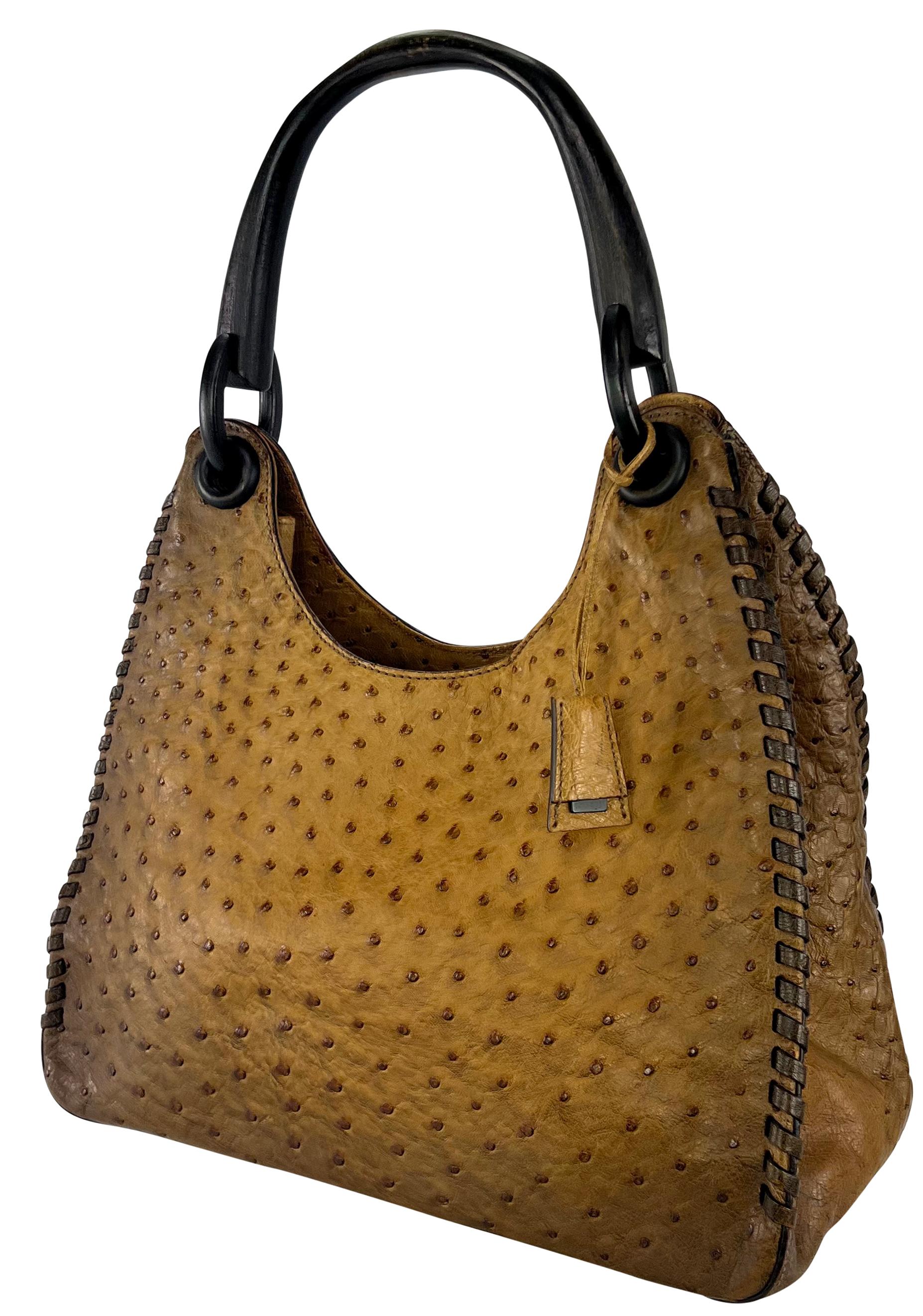 Tom Ford designed this stunning tan ombré ostrich skin Gucci tote for the Fall/Winter 2002 collection. Crafted from tan-hued ostrich skin, the bag features a blackened wood handle, whipstitch detailing, and a small branded Gucci charm. 