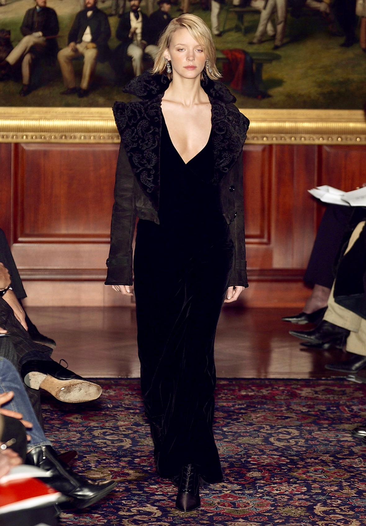 This elegant yet sexy Ralph Lauren Purple Label gown debuted on the season's runway as part of look 29, modeled by Betina Holte. This effortlessly chic soft velvet dress features a deep v-neckline, wide shoulder straps, a low semi-exposed back, and