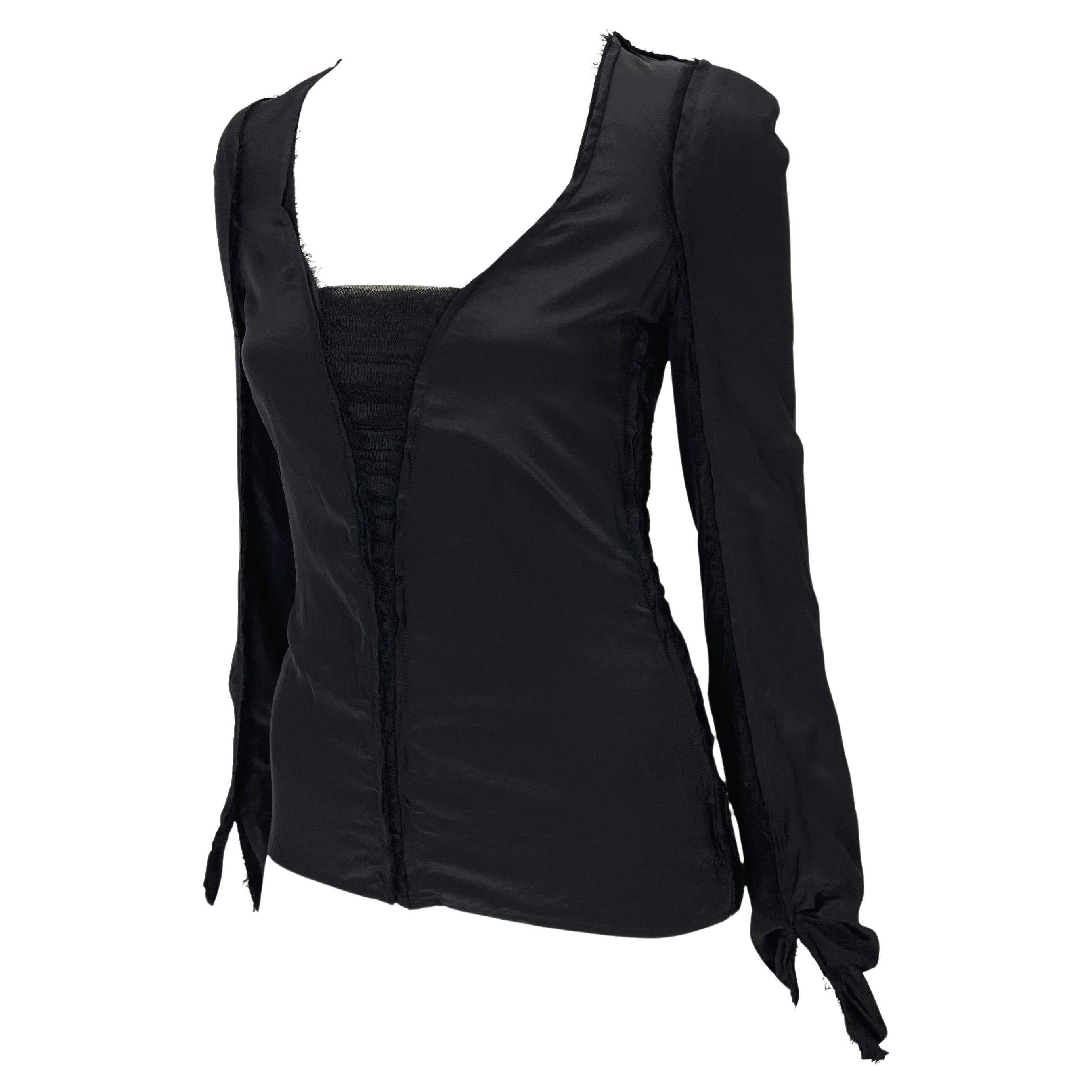 Ti presentiamo un top Yves Saint Laurent Rive Gauche nero a maniche lunghe con bordi grezzi, disegnato da Tom Ford. Dalla collezione Autunno/Inverno 2002, questo top presenta dettagli in organza trasparente che collegano pannelli di seta. Questo