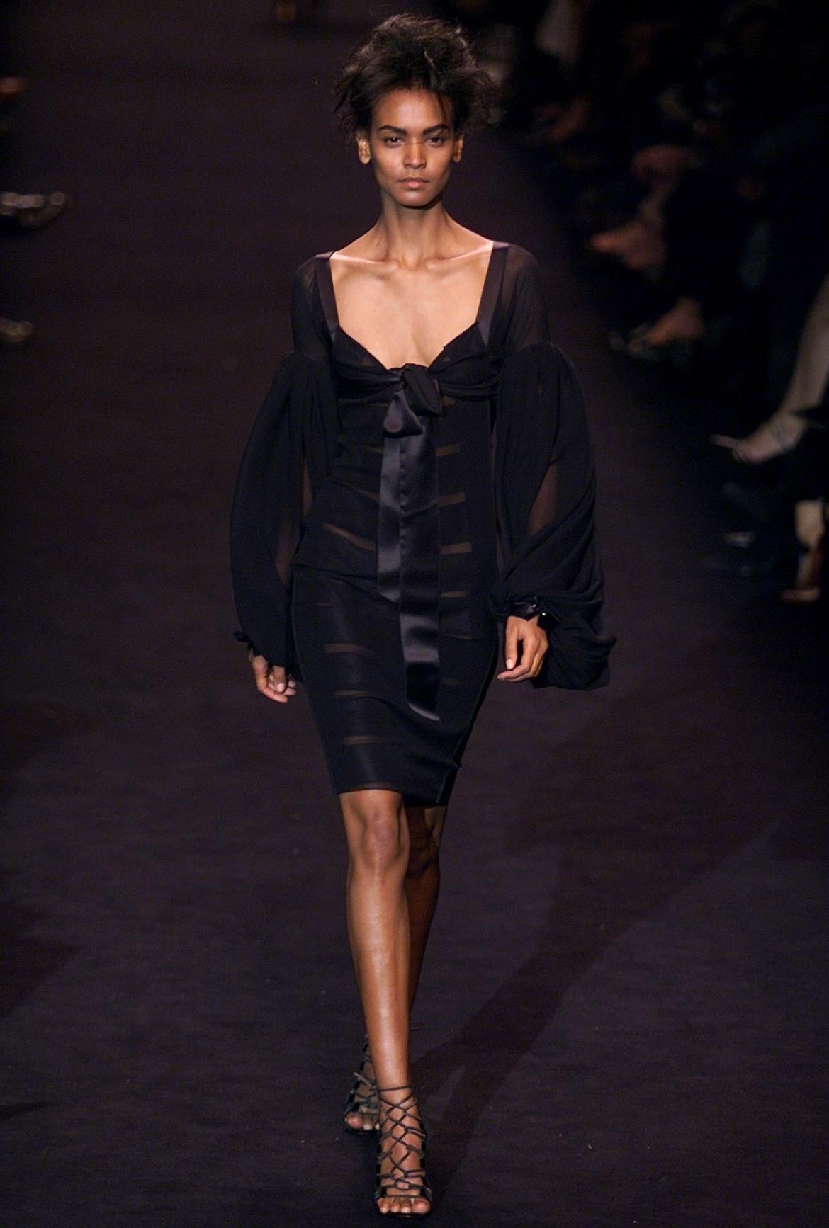 Voici une magnifique robe noire à manches de poète Yves Saint Laurent Rive Gauche, dessinée par Tom Ford. Issue de la collection Automne/Hiver 2002, cette robe a fait ses débuts sur le défilé de la saison en tant que look 37 porté par Liya Kebede.