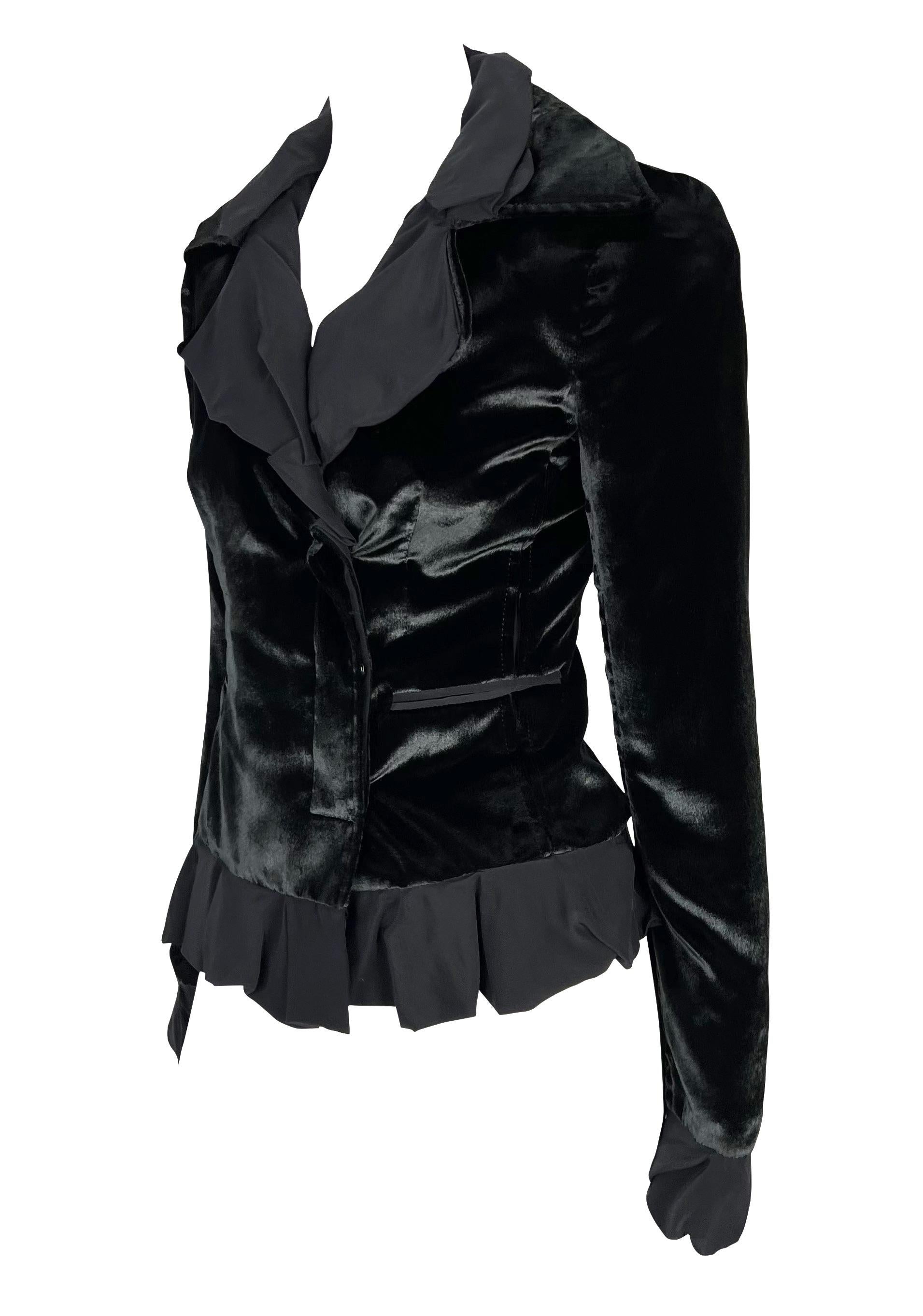 Voici un magnifique blazer Yves Saint Laurent en velours noir, dessiné par Tom Ford. Issu de la collection Automne/Hiver 2002, ce magnifique blazer est réalisé en velours noir chatoyant et présente des volants de mousseline à l'ourlet, au col et aux