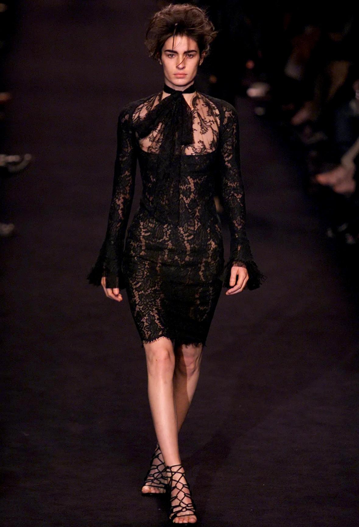 This gorgeous black lace dress from Yves Saint Laurent Rive Gauche, designed by Tom Ford, is from the Fall/Winter 2002 collection. It debuted on the runway as Look 33, modeled by Amanda Moore. This stunning dress is adorned with intricate lace and