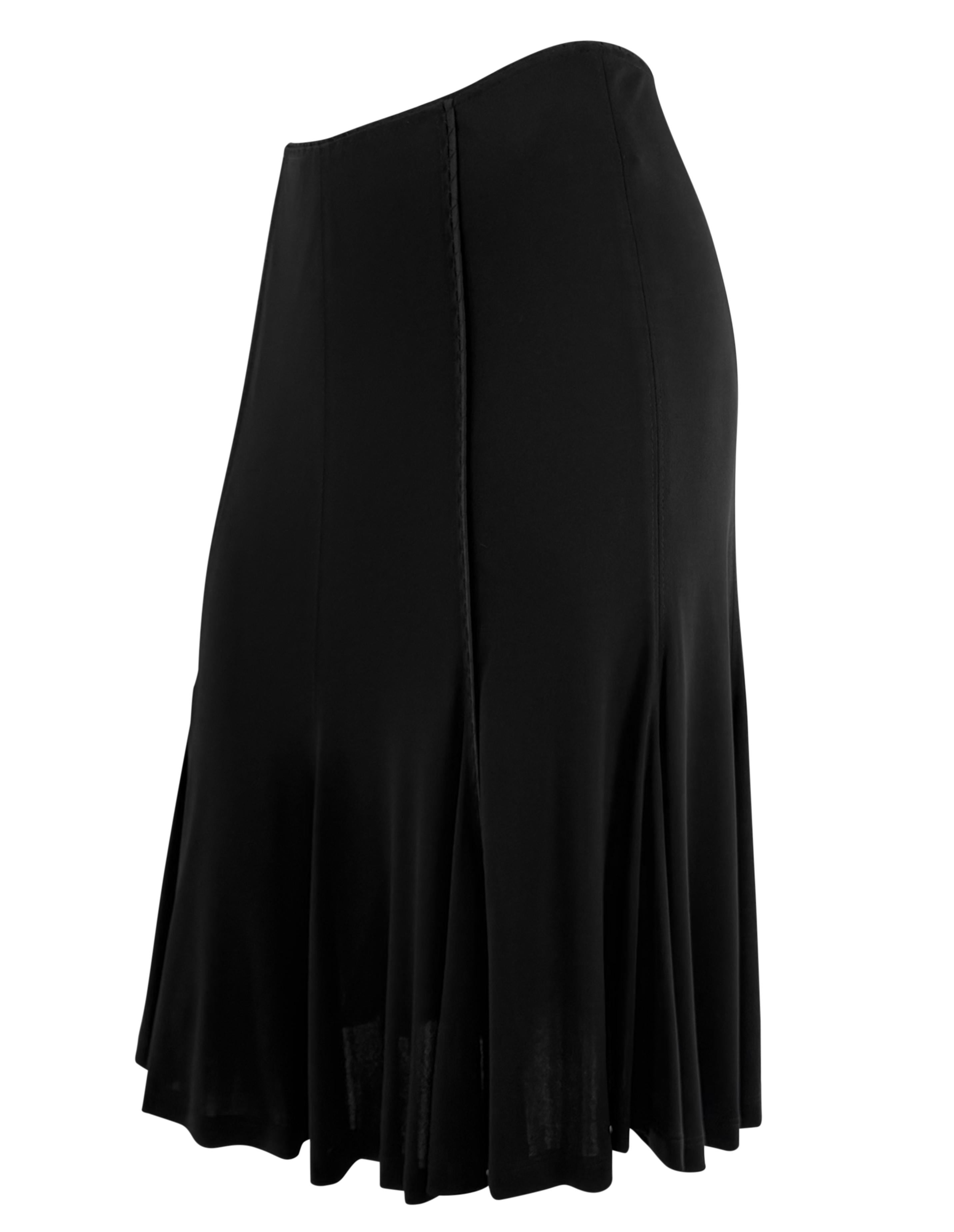 Issue de la collection automne/hiver 2002 d'Yves Saint Laurent sous la direction de Tom Ford, cette jupe noire présente une coupe bodycon à panneaux qui s'évase subtilement à l'ourlet. Ce modèle est orné d'une bordure en satin ton sur ton.

Mesures