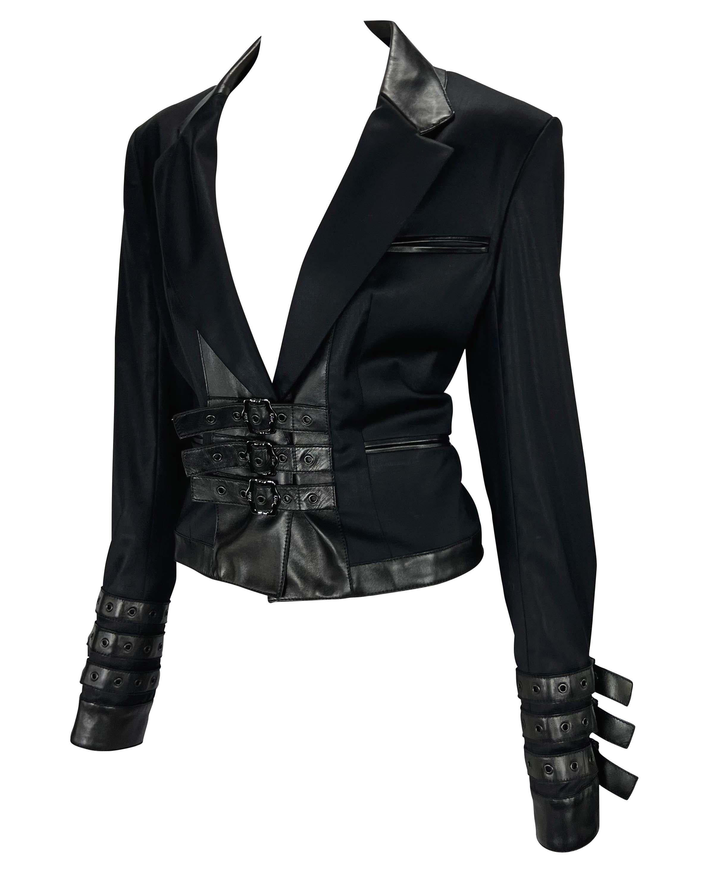 TheRealList presents: a black leather accented Christian Dior Boutique buckle blazer, designed by John Galliano. From the Fall/Winter 2003 collection, this bondage-inspired blazer features a plunging v-neckline, pockets at the bust and hips, and a