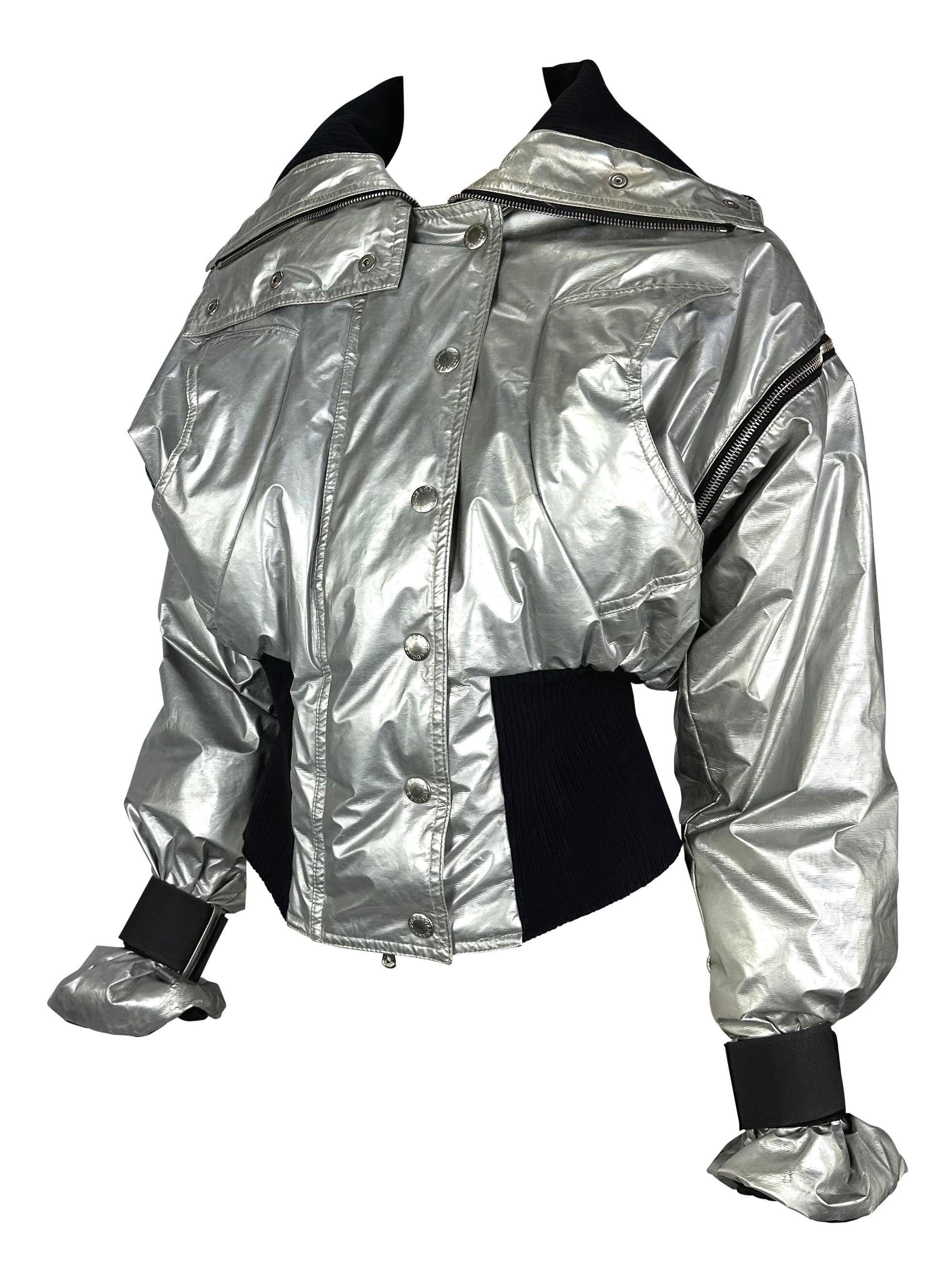 Presenting a fabulous silver metallic Dolce and Gabbana puffer jacket. From the Fall/Winter 2003 collection, this incredible oversized jacket features snap closures at the front, zippers around the shoulders, and velcro wraps at the wrists. The